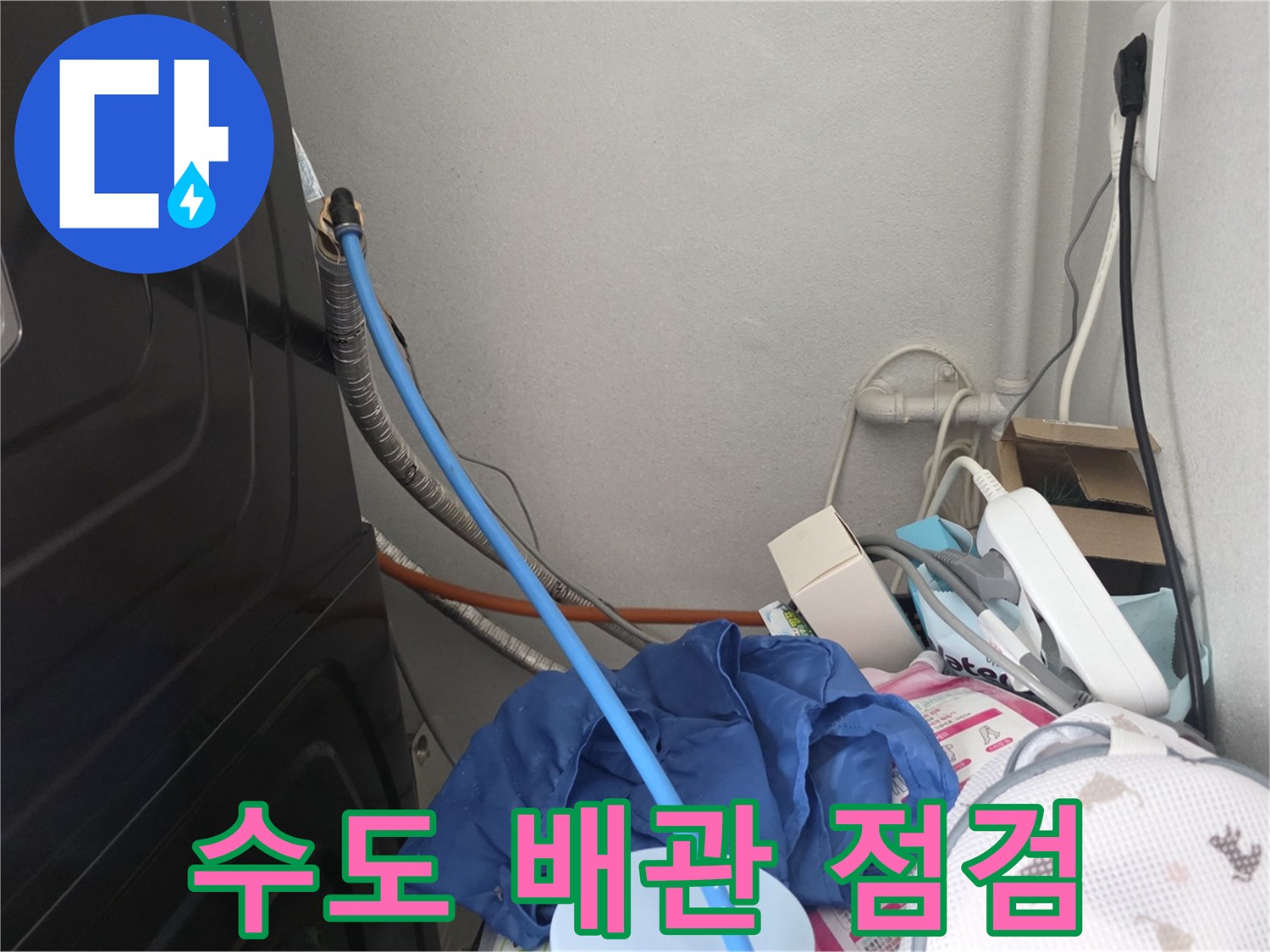 세탁실 구석 배관에 연결된 파란색 압력 측정 호스