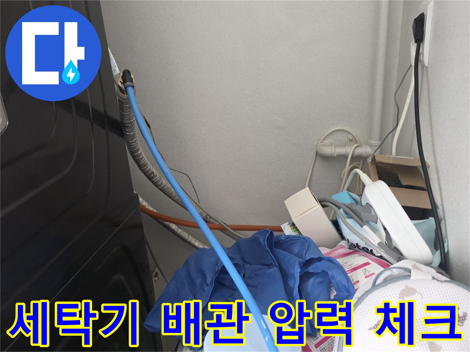 좁은 틈 사이로 연결된-파란색 공압 호스와 수도 배관
