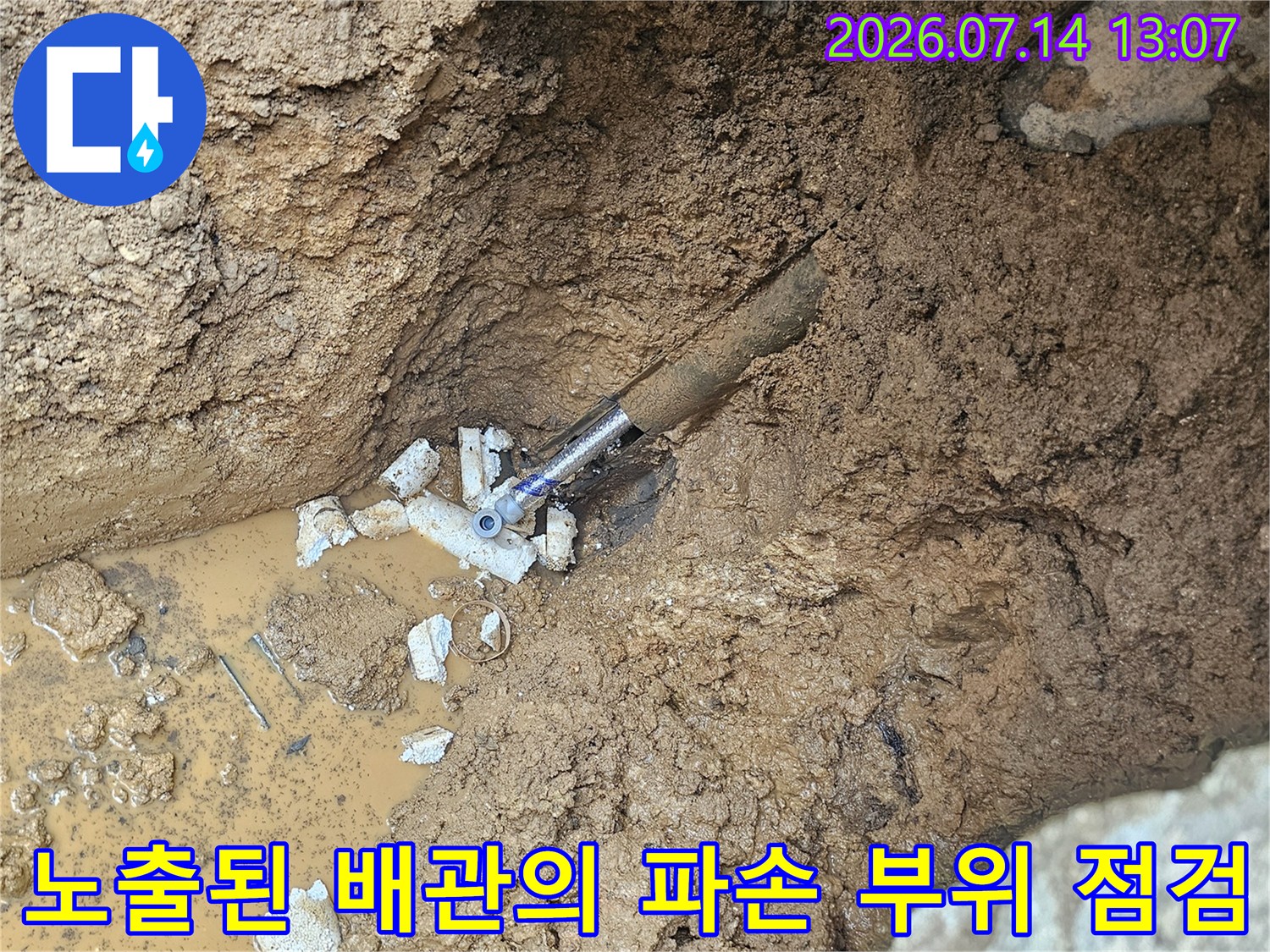 흙 속에서 발견한 누수로 젖은 배관 연결부와 고인 물