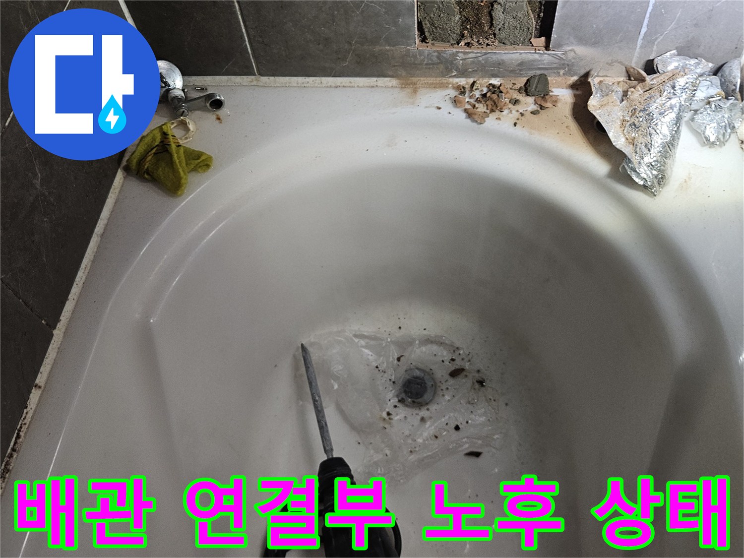 욕조 내부-노출된 수전 배관과 파손된 타일