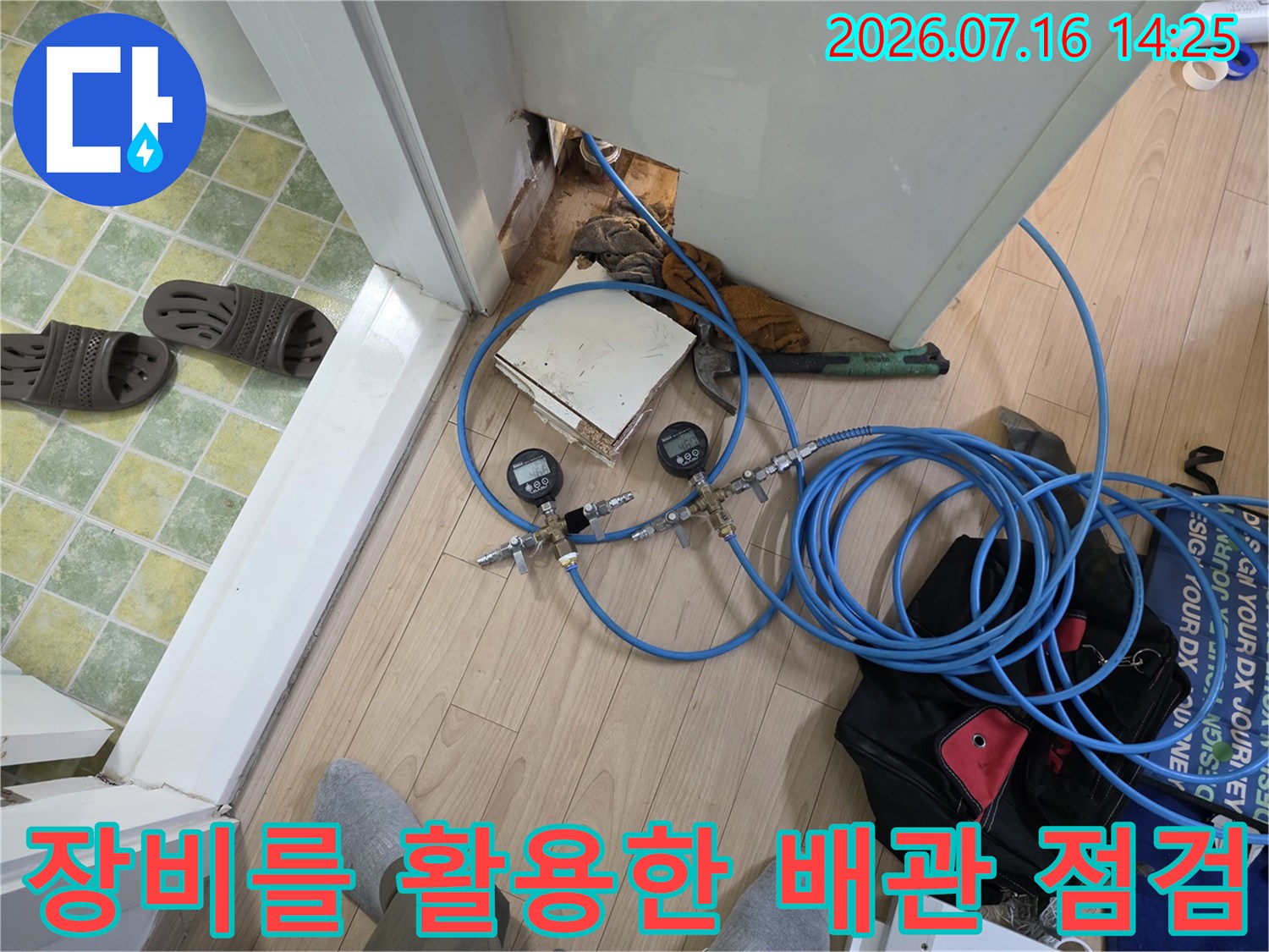 분배기 함 근처에서 정밀 장비와 호스를 연결해 압력을 체크하는 작업 모습