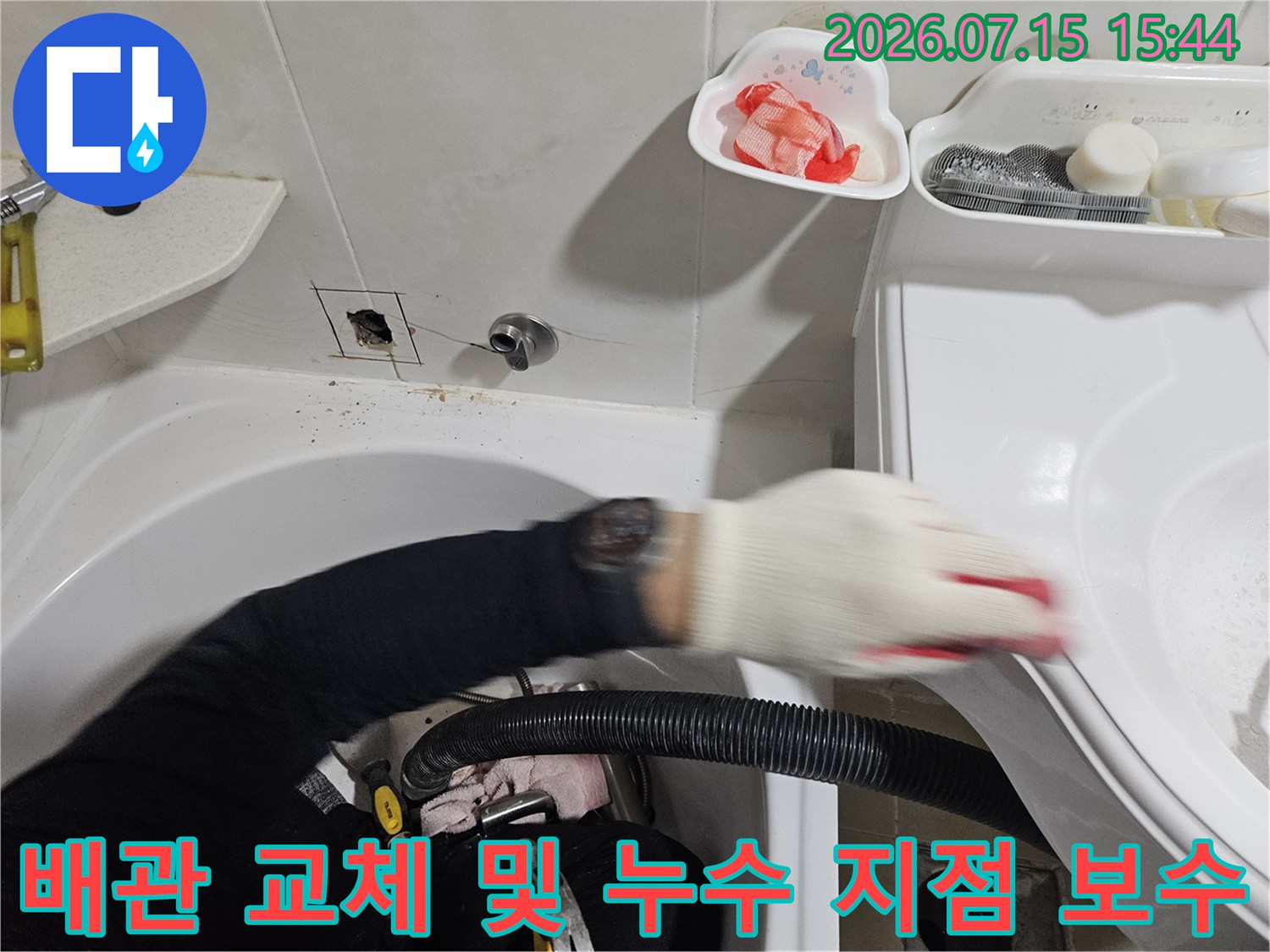 세면대 아래쪽의 파손된 배관 부위를 전문 장비를 사용하여 교체하는 모습