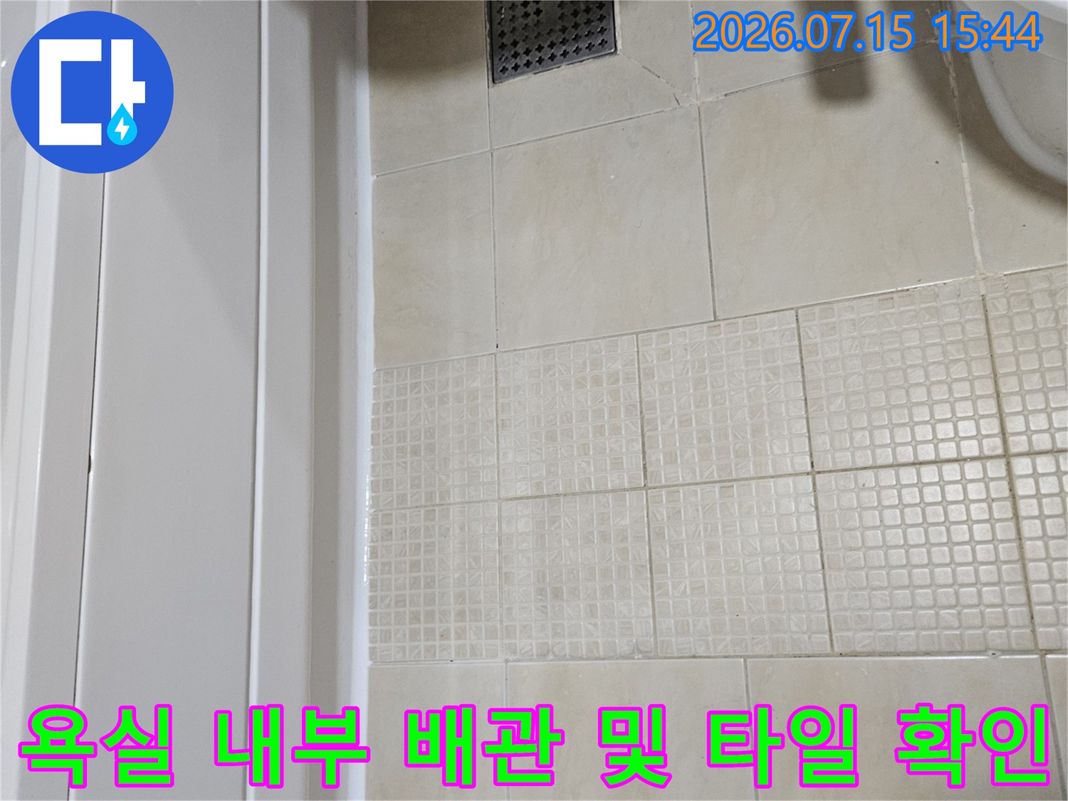세면대 주변의 타일 마감과 하부 배관 시설을 촬영한 모습