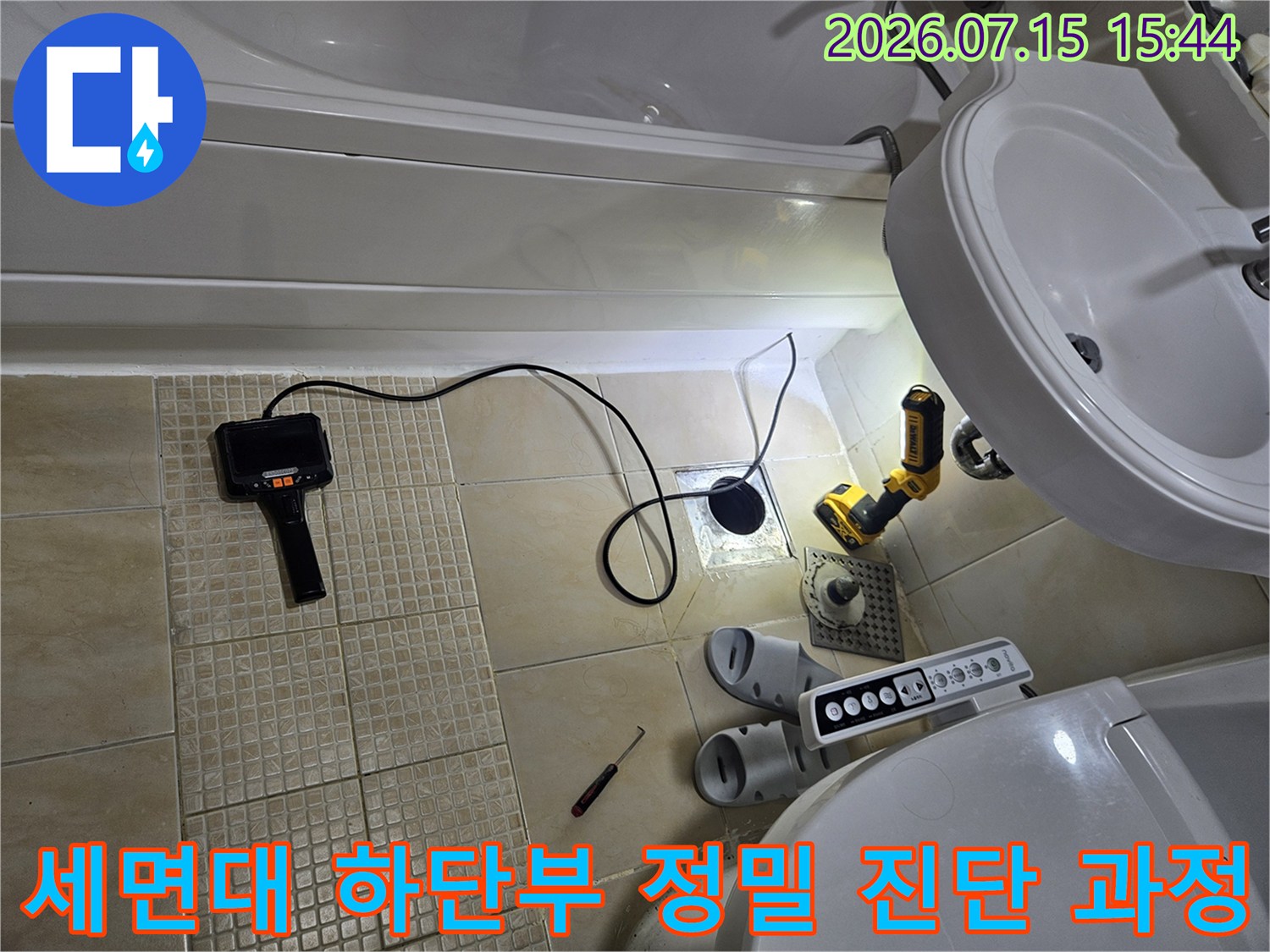 탐지기 및 공구가 배치된 세면대 밑쪽 배관 점검 모습