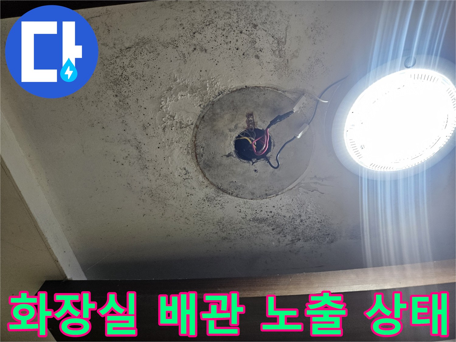 화장실 천장 부근-노출된 배관 연결부와 오염된 벽면