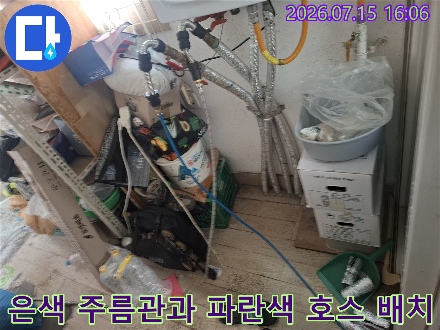보일러 하단에 설치된 금속제 주름관-파란색 플라스틱 배관이 연결되어 내려오는 모습