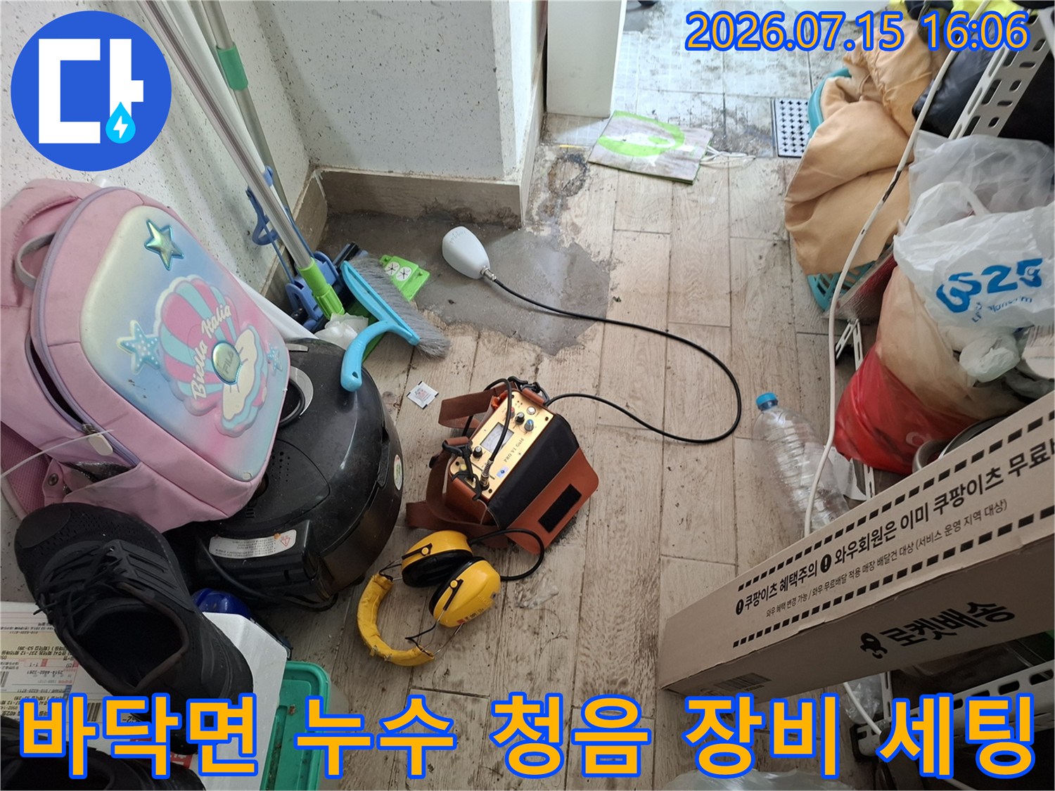 타일 바닥 위에 배치된 누수 탐지기-헤드셋과 측정 센서 연결 상태