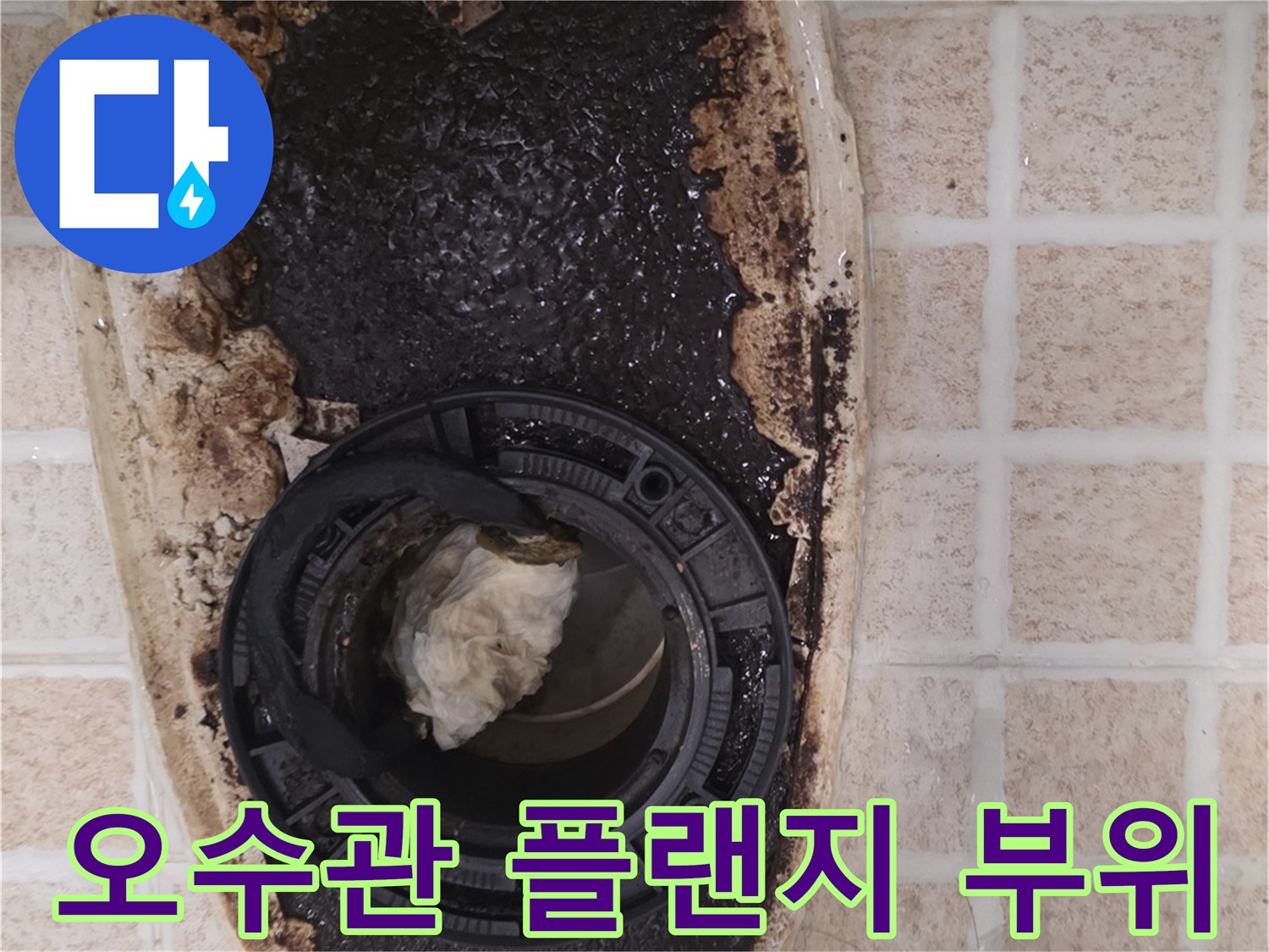 배수구 관로 주변의 찌꺼기와 오염된 타일 상태를 나타냅니다.