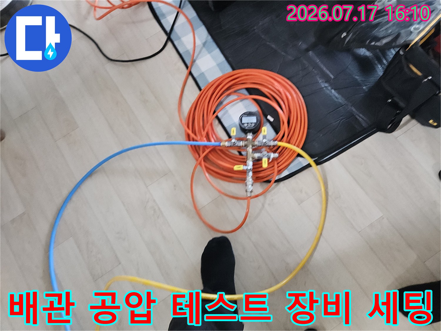 노란색과파란색 호스를 연결한 배관 압력 측정 장비 모습
