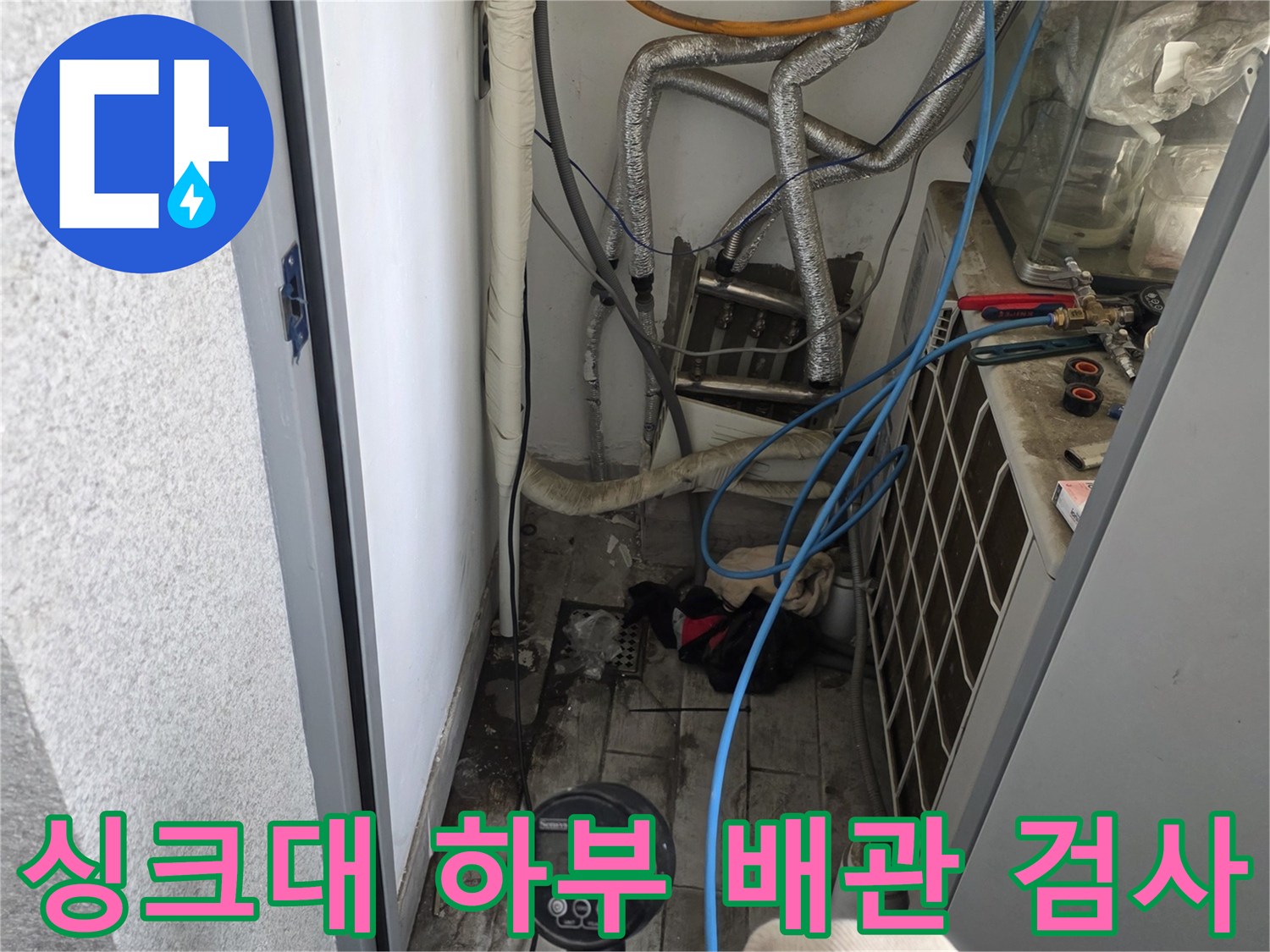 싱크대 아래쪽-청색 호스와 게이지를 이용한 배관 압력 측정 작업