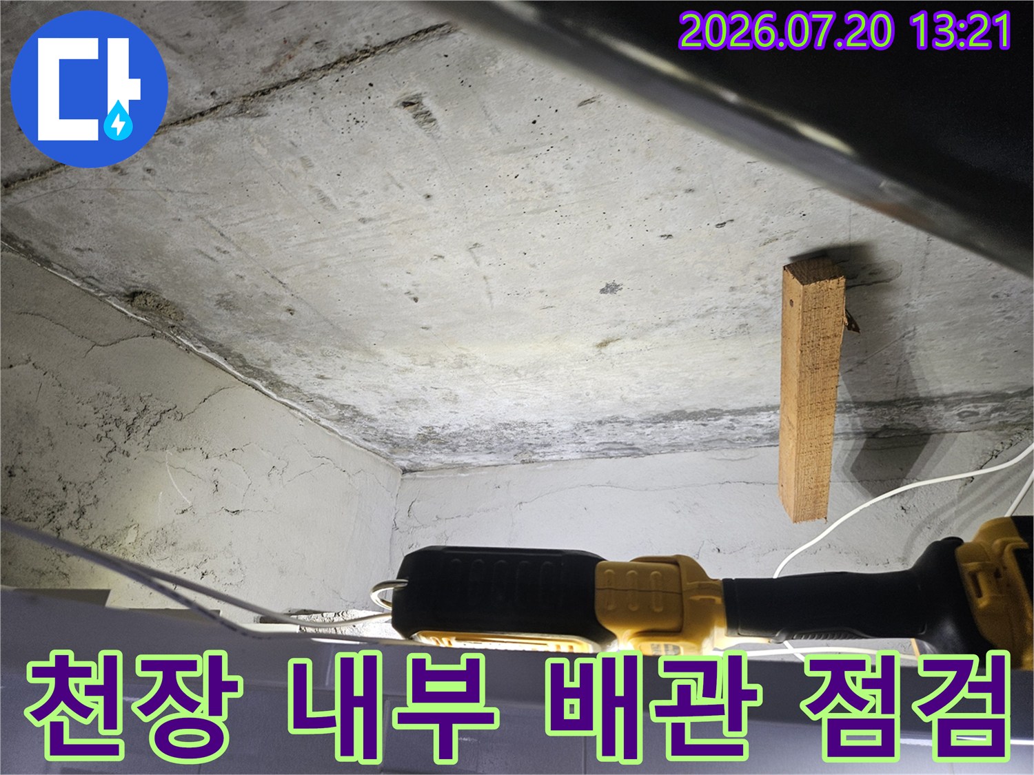 노출된 천장 내부의 배관과 콘크리트 구조물을 점검하는 모습