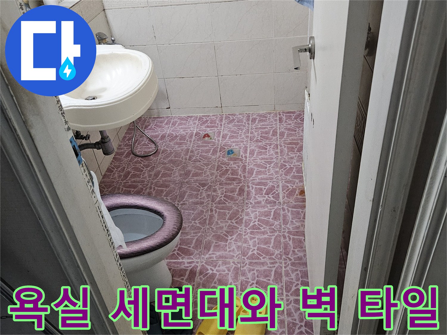 세면대 주변의 분홍색 패턴 타일을 촬영한 사진