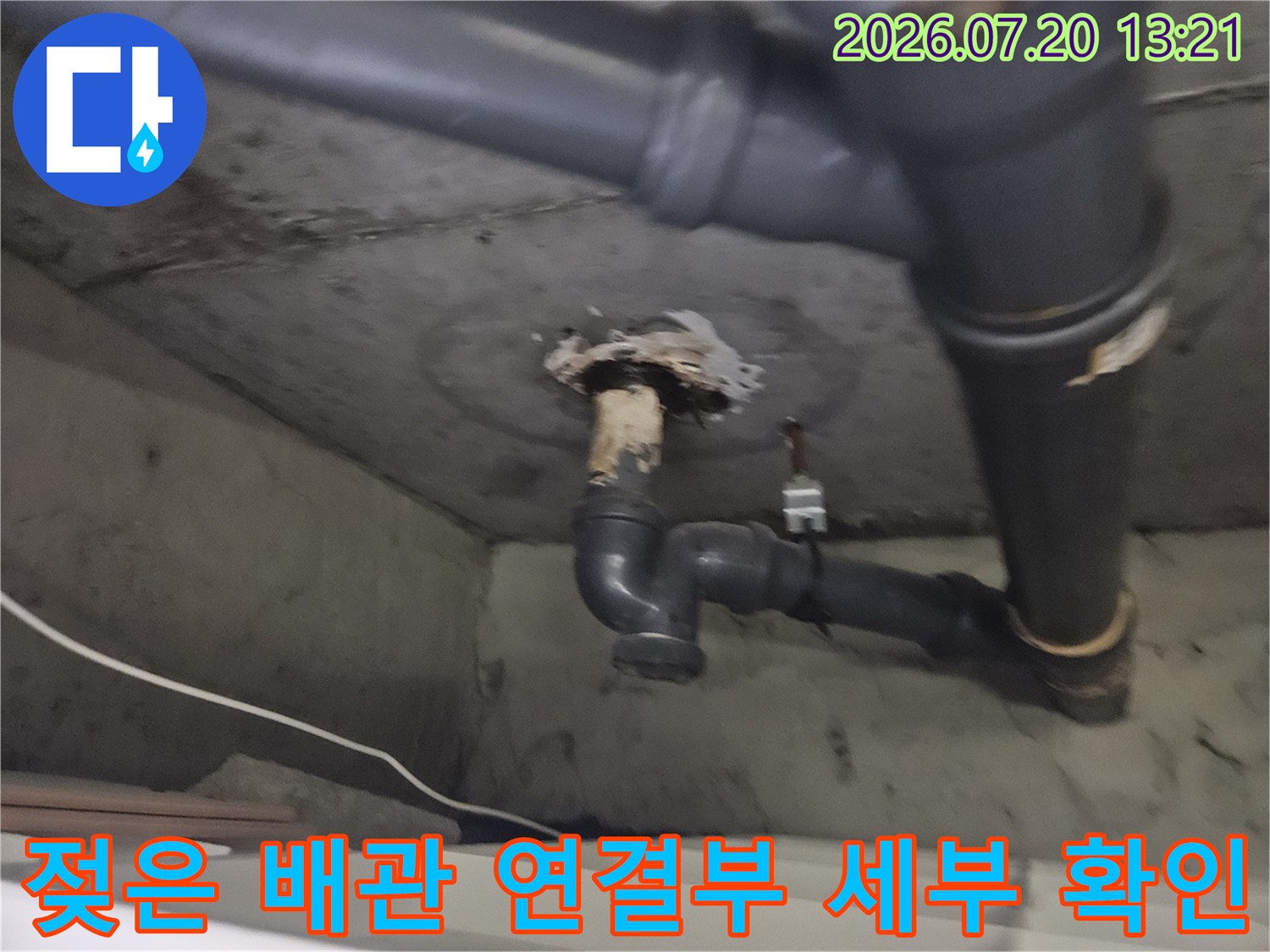 세탁실 바닥에 노출된 젖고 오염된 배관 연결 부위 사진