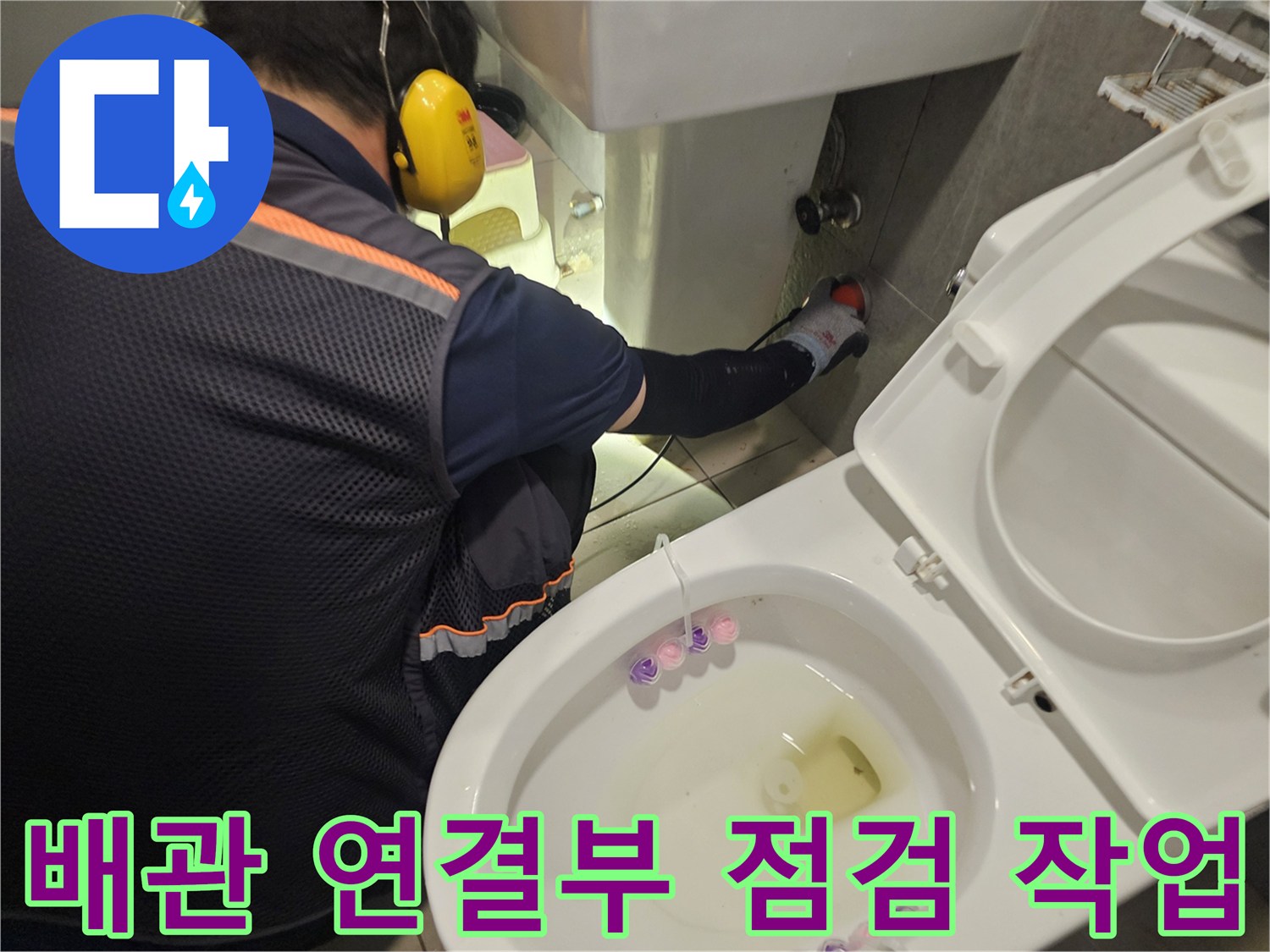 엔지니어가 변기 뒤쪽 벽면 배관의 누수 여부를 집중적으로 검사하고 있습니다.