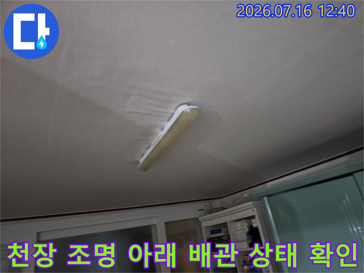 화장실 천장 내부의 노출된 전등과 주변 마감재 점검 모습