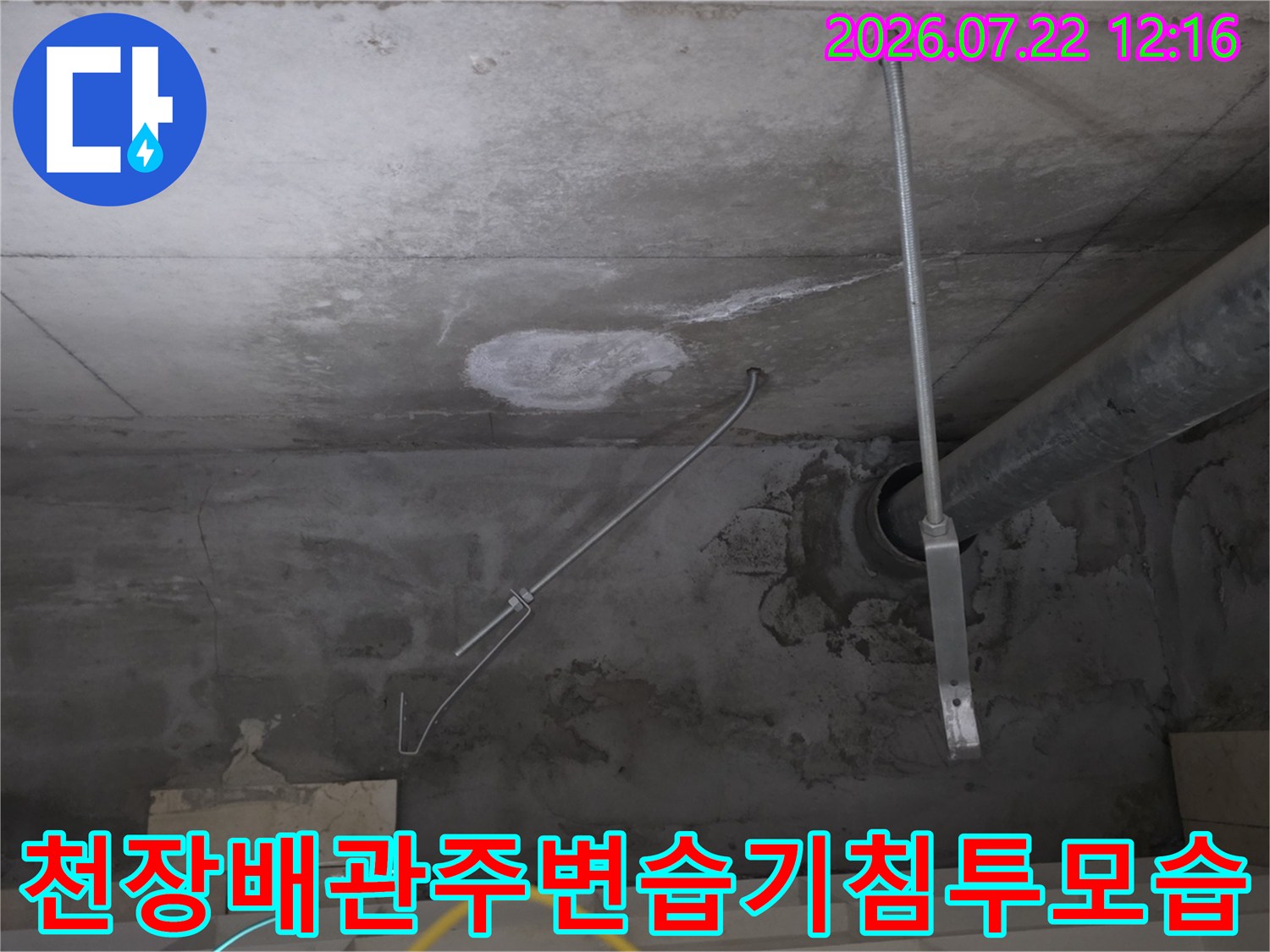 배관 지지대 옆 콘크리트 천장에 발생한 누수 얼룩과 습기 흔적