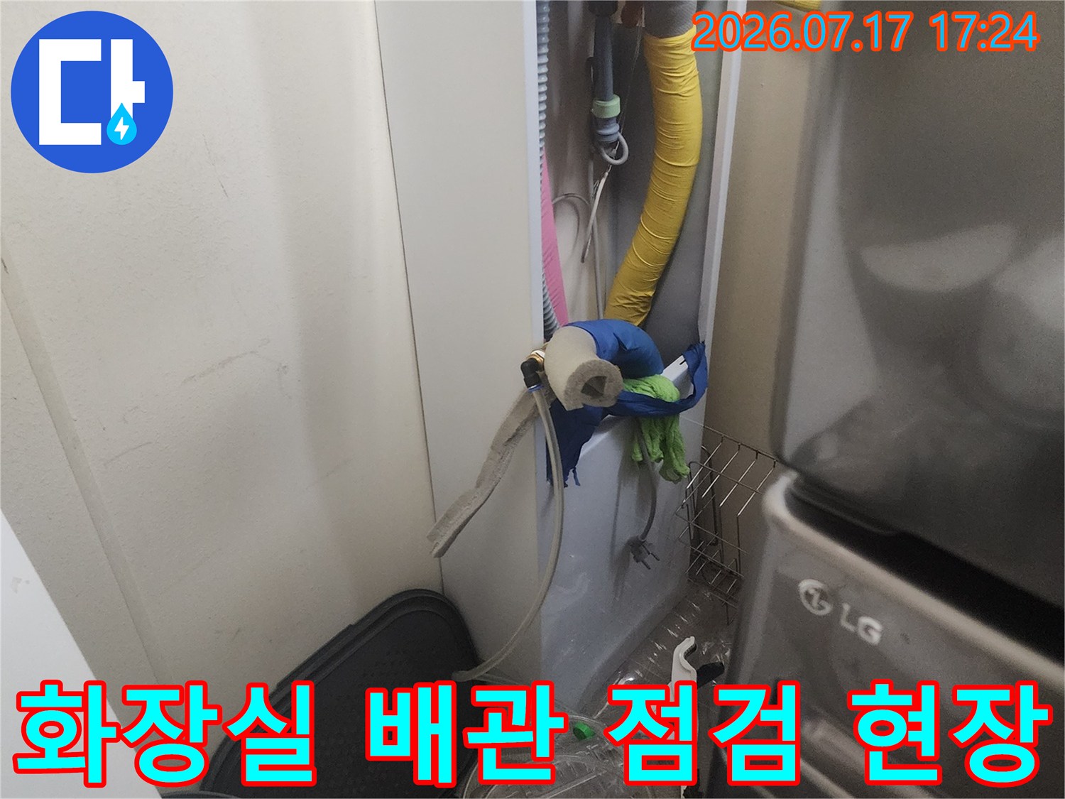 노출된 화장실 배관에 장비를 연결하여 정밀하게 누수 여부를 측정하는 장면