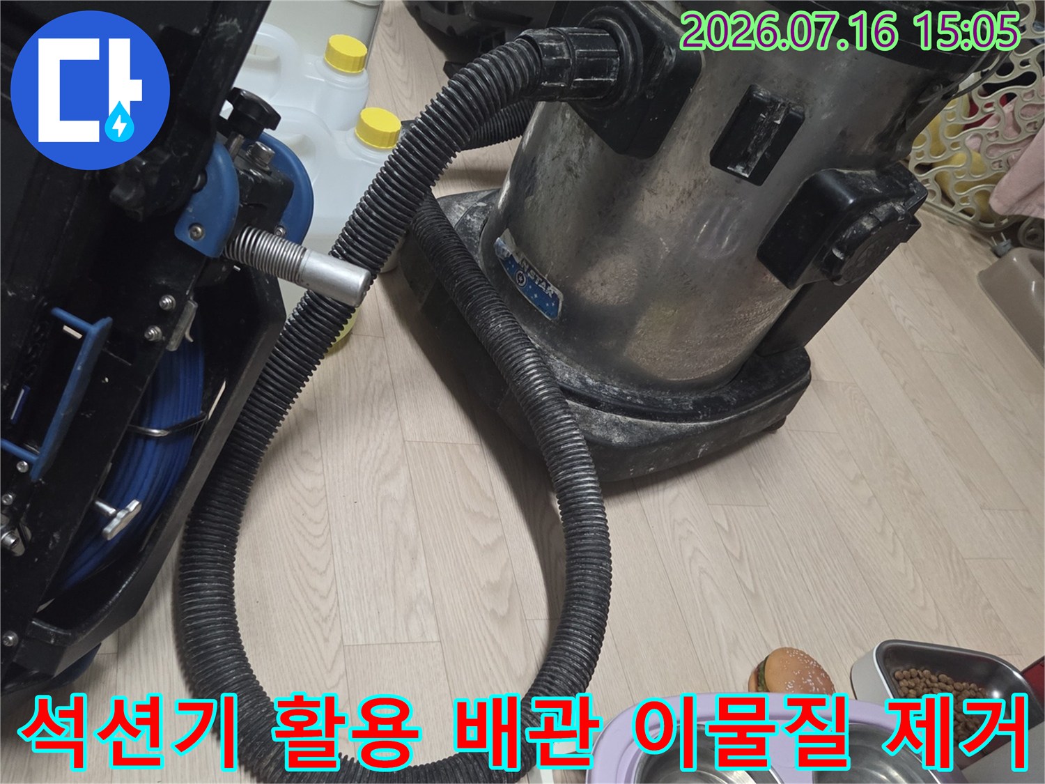 싱크대 하부 배수관에 석션기를 연결하여 내부 오물을 흡착하는 장면