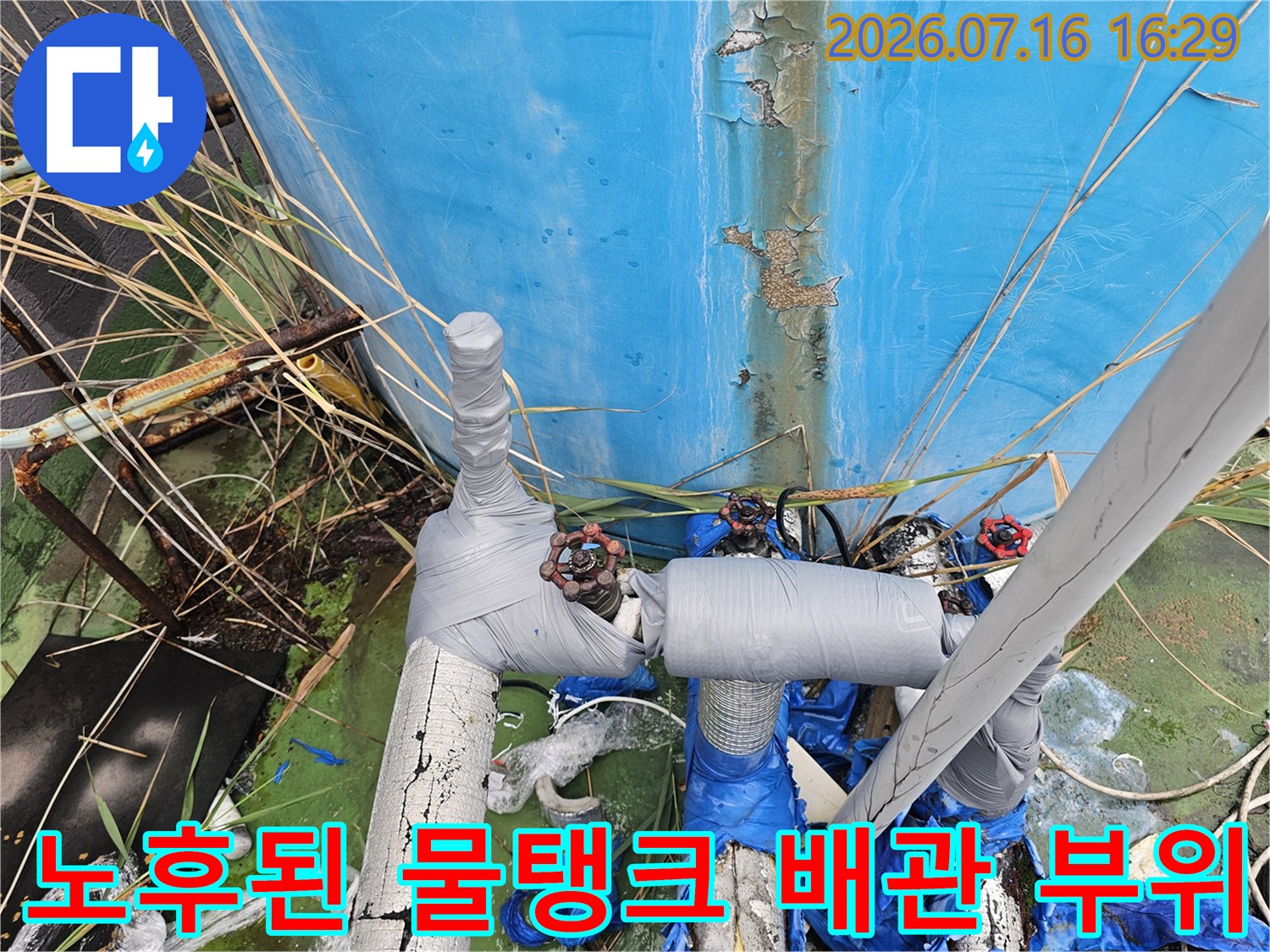 녹슬고 노후되어 테이핑 처리가 된 물탱크 연결부 배관 사진