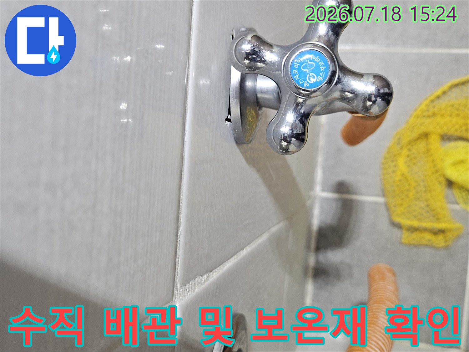 보온재가 덮인 수직 배관과 수전의 상세 모습