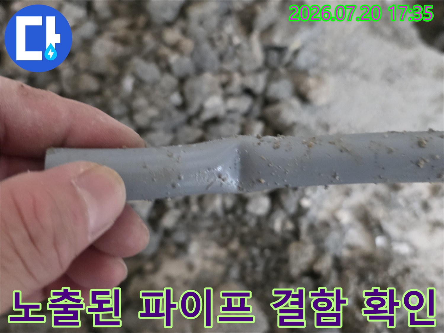 회색 배관의 손상 구간을 분리하기 위해 직접 손으로 잡고 있는 모습