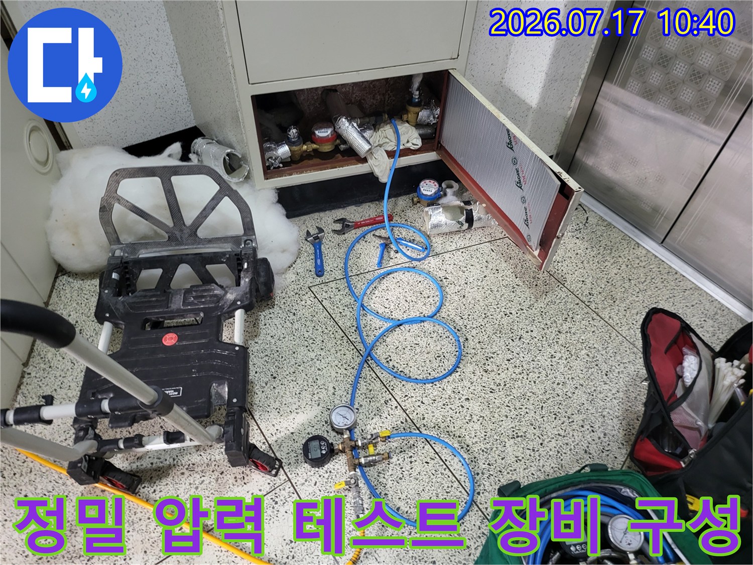 다양한 게이지와 파란색 호스를 연결하여 배관 시스템의 이상을 점검하는 과정