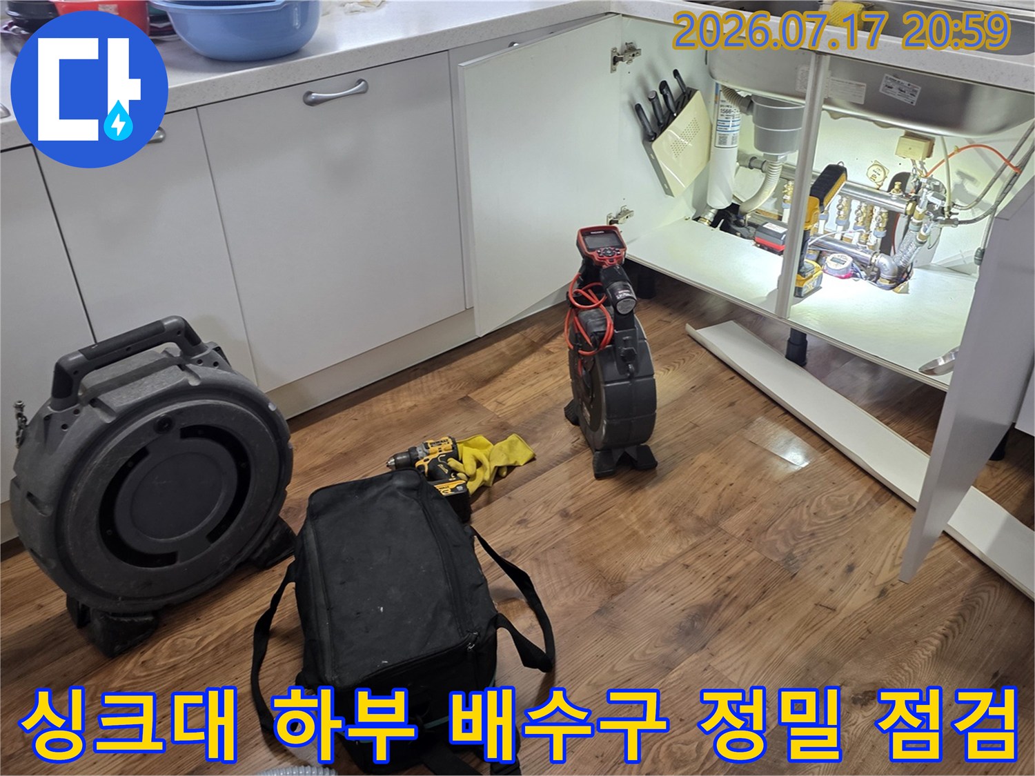 싱크대 아래 공간에서 전문 장비를 활용해 배수관 상태를 정밀하게 진단하는 모습