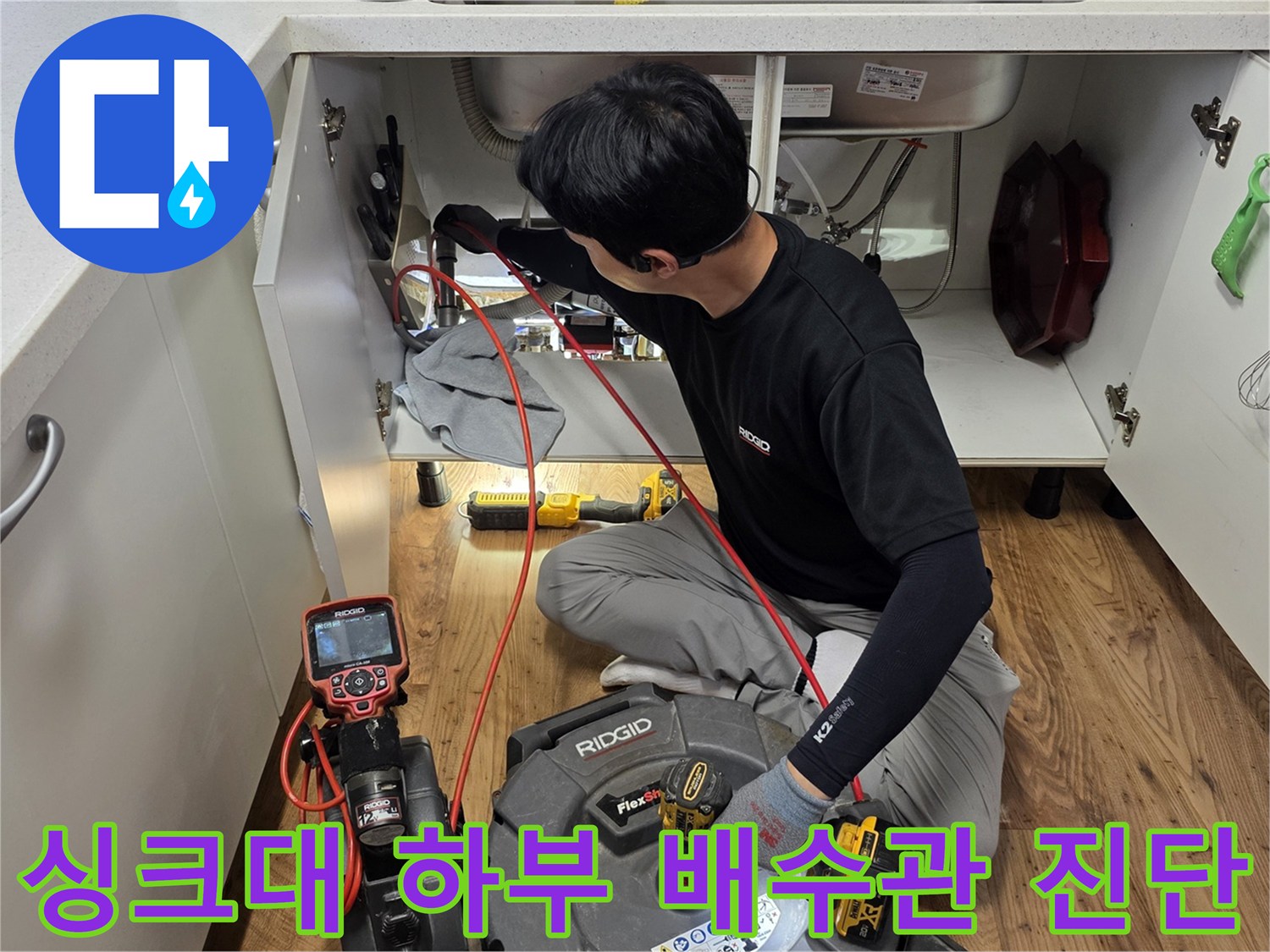 싱크대 아래쪽 공간에서 진행되는 배수관 정밀 검사 장면