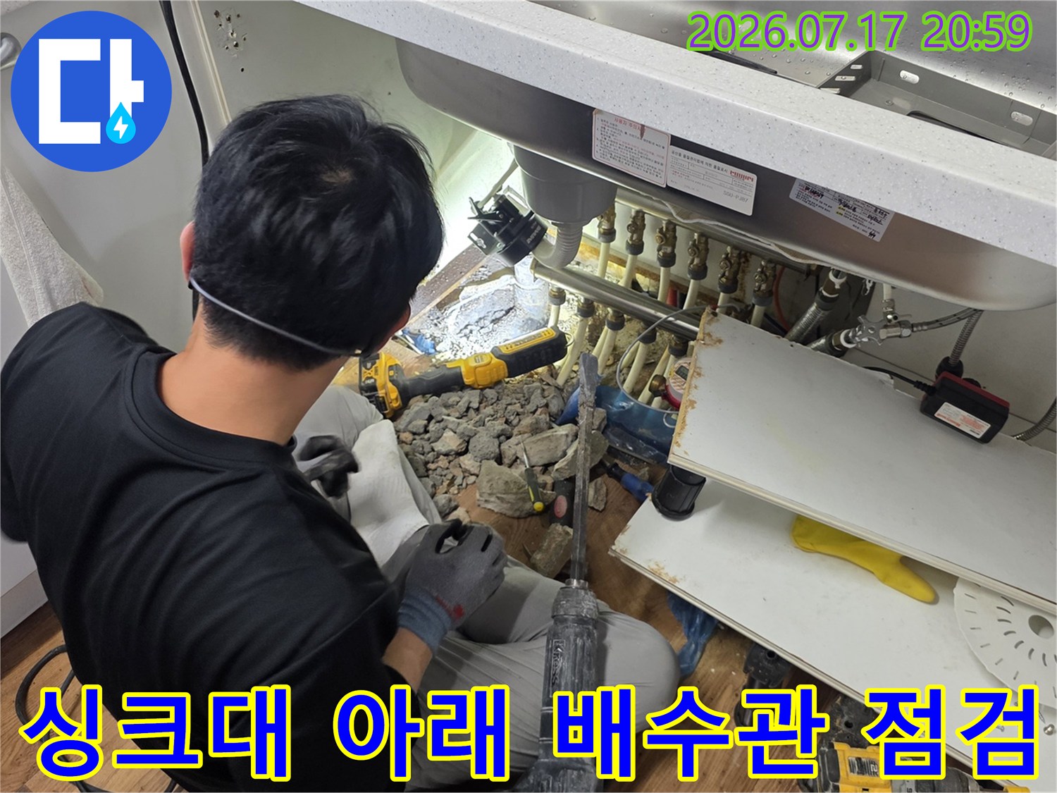 싱크대를 제거하고 노출된 하부 배수관을 정밀하게 점검하는 모습