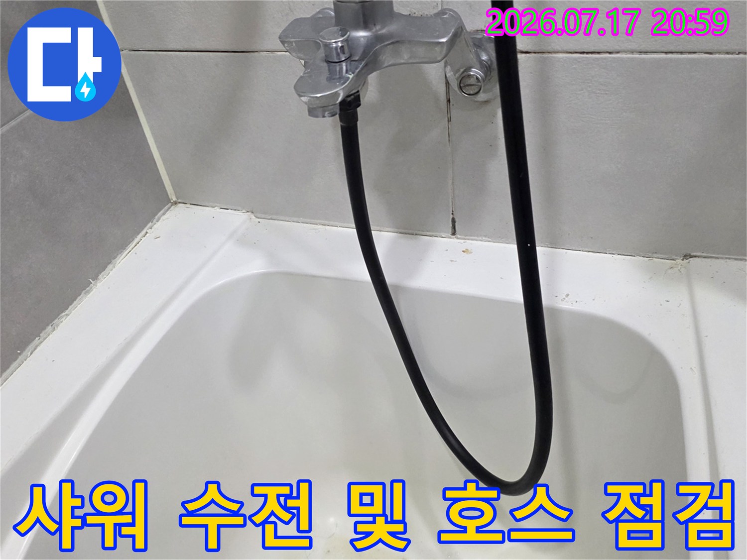 은색 금속제 샤워 수전과 검정색 배관 호스가 연결된 상세 촬영