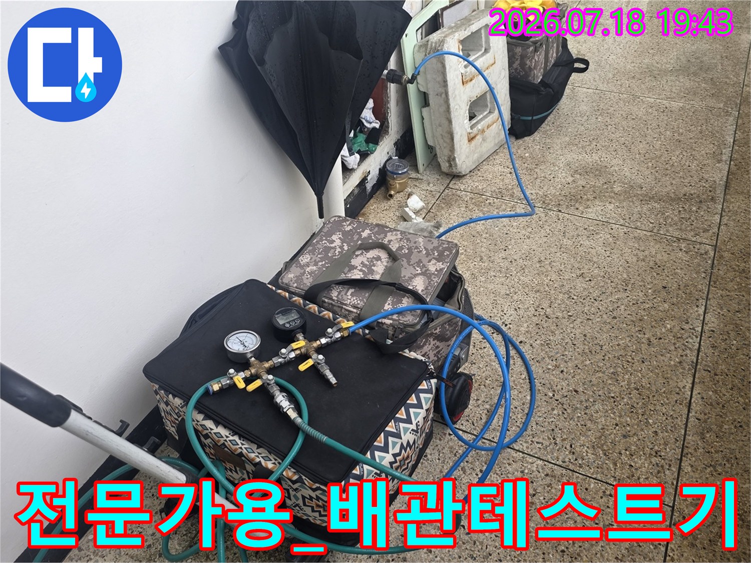고압 테스트를 위해 배관에 호스를 연결한 누수 탐지 현장 사진