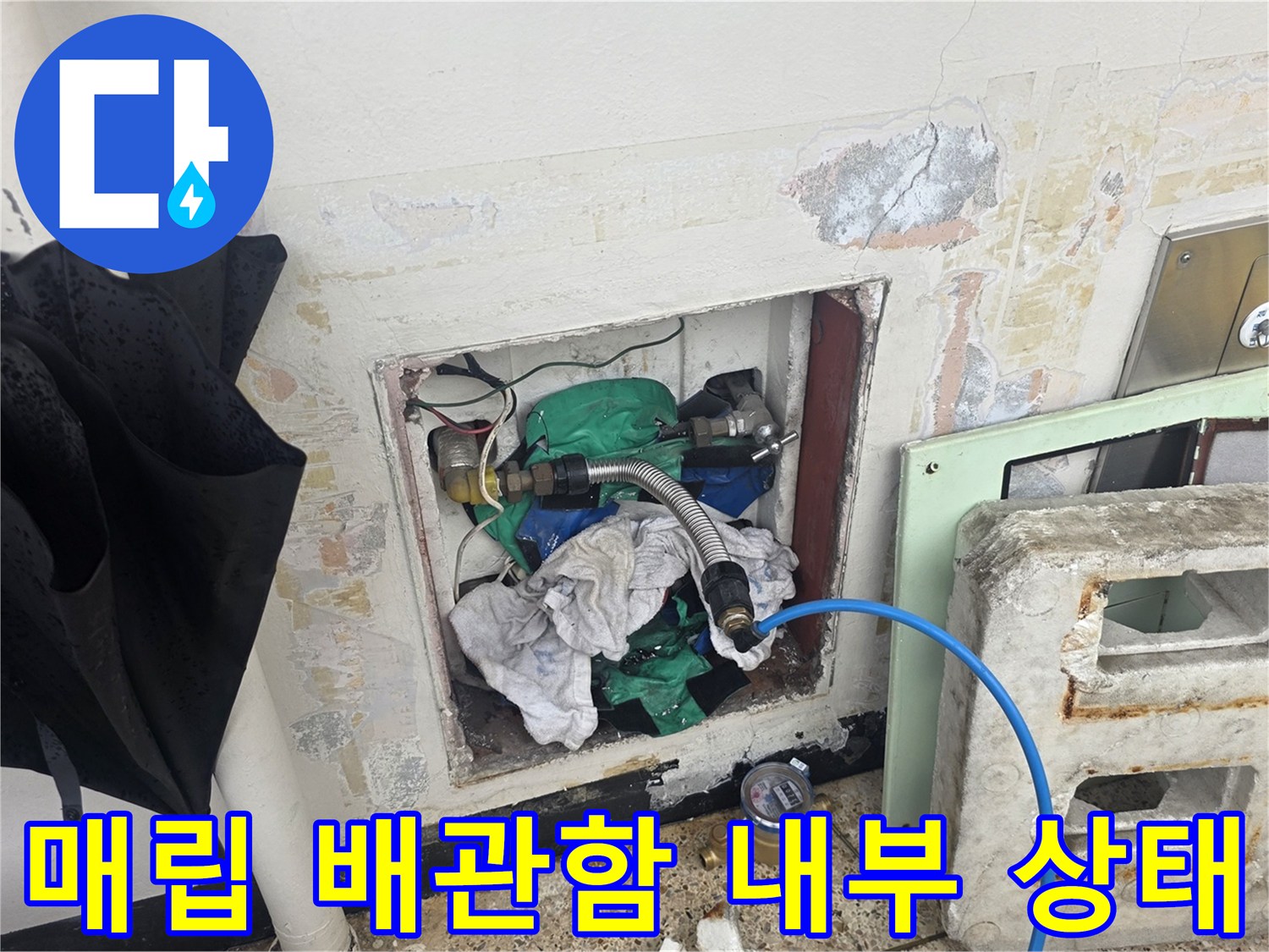 벽체 매립 배관 함 내부에 노출된 배관과 젖은 마감재를 보여줍니다.