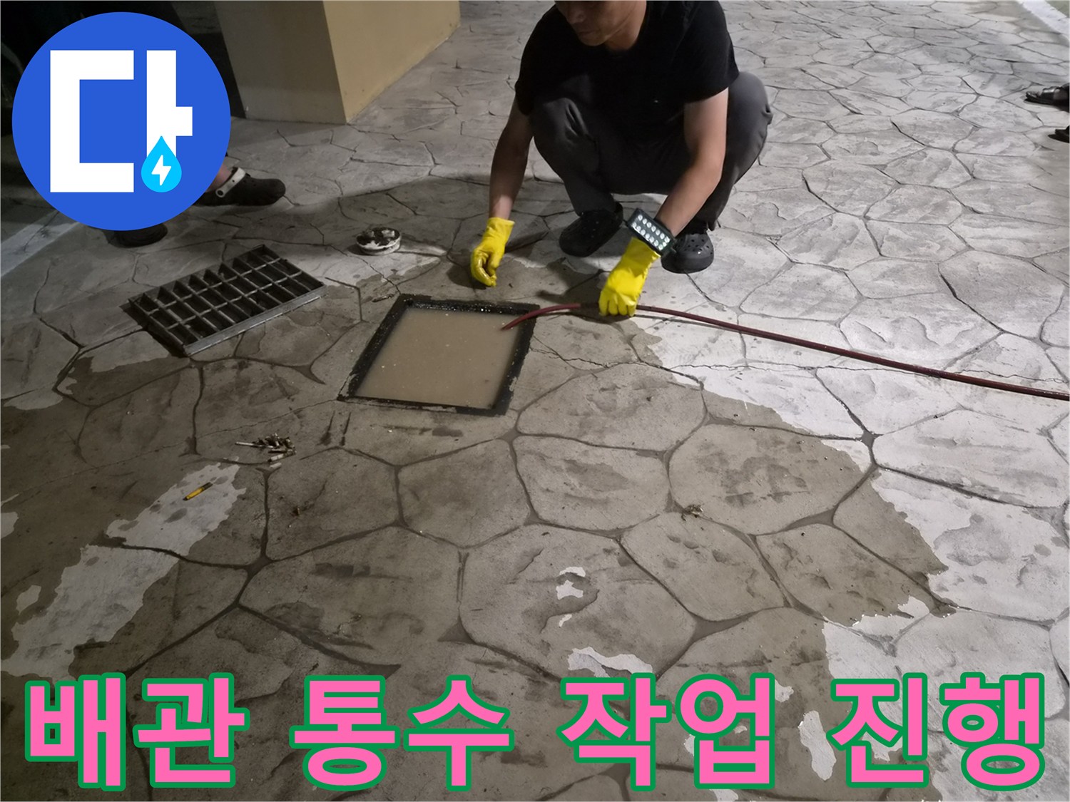 열려 있는 배관 부위에-전동 장비를 넣어 청소하는 과정
