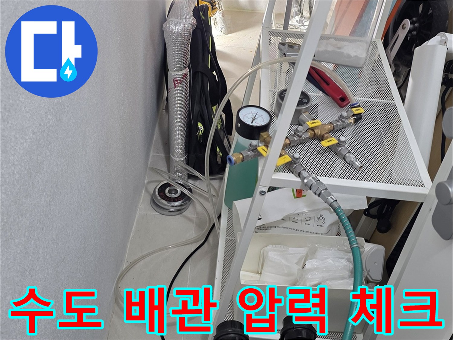 누수 탐지를 위해 배관에 연결된 공압 테스트 장비와 게이지