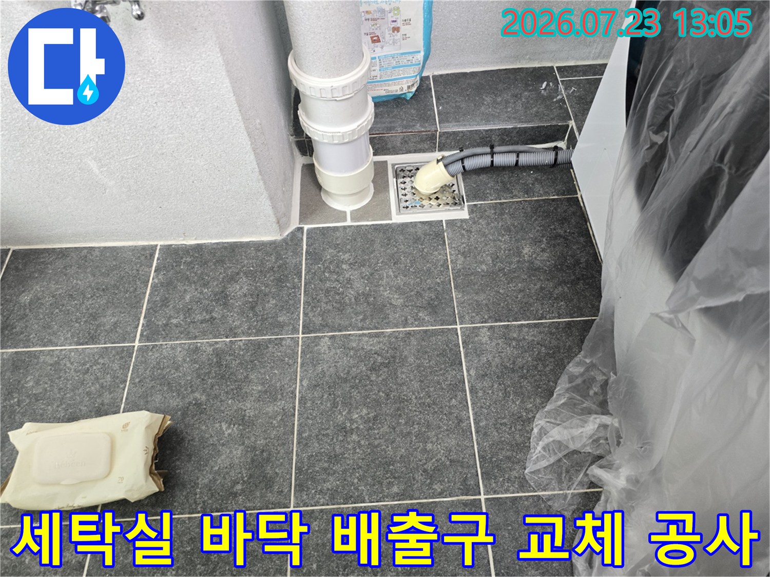 파손된 세탁기용 배수 홈통을 제거하고 새 부속으로 견고하게 연결하는 모습