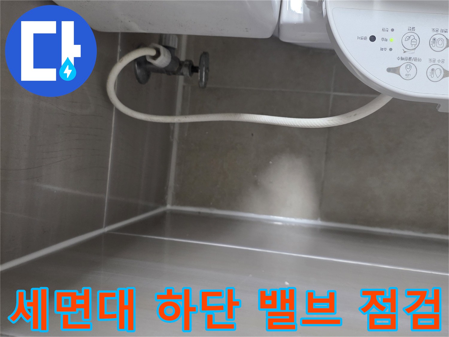 세면대 아래쪽 수도 밸브와 연결 호스의 근접 촬영 이미지
