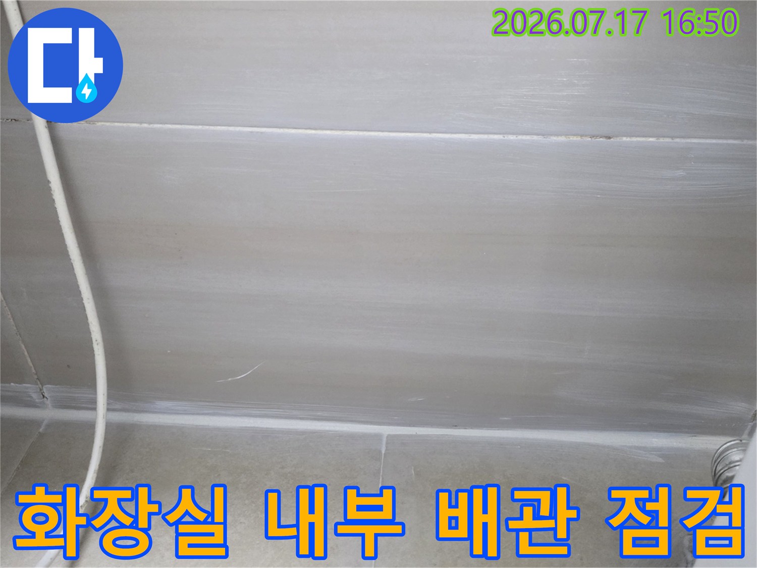 화장실 천장 안쪽으로 노출된 배관과 주변 벽면을 조사하는 장면