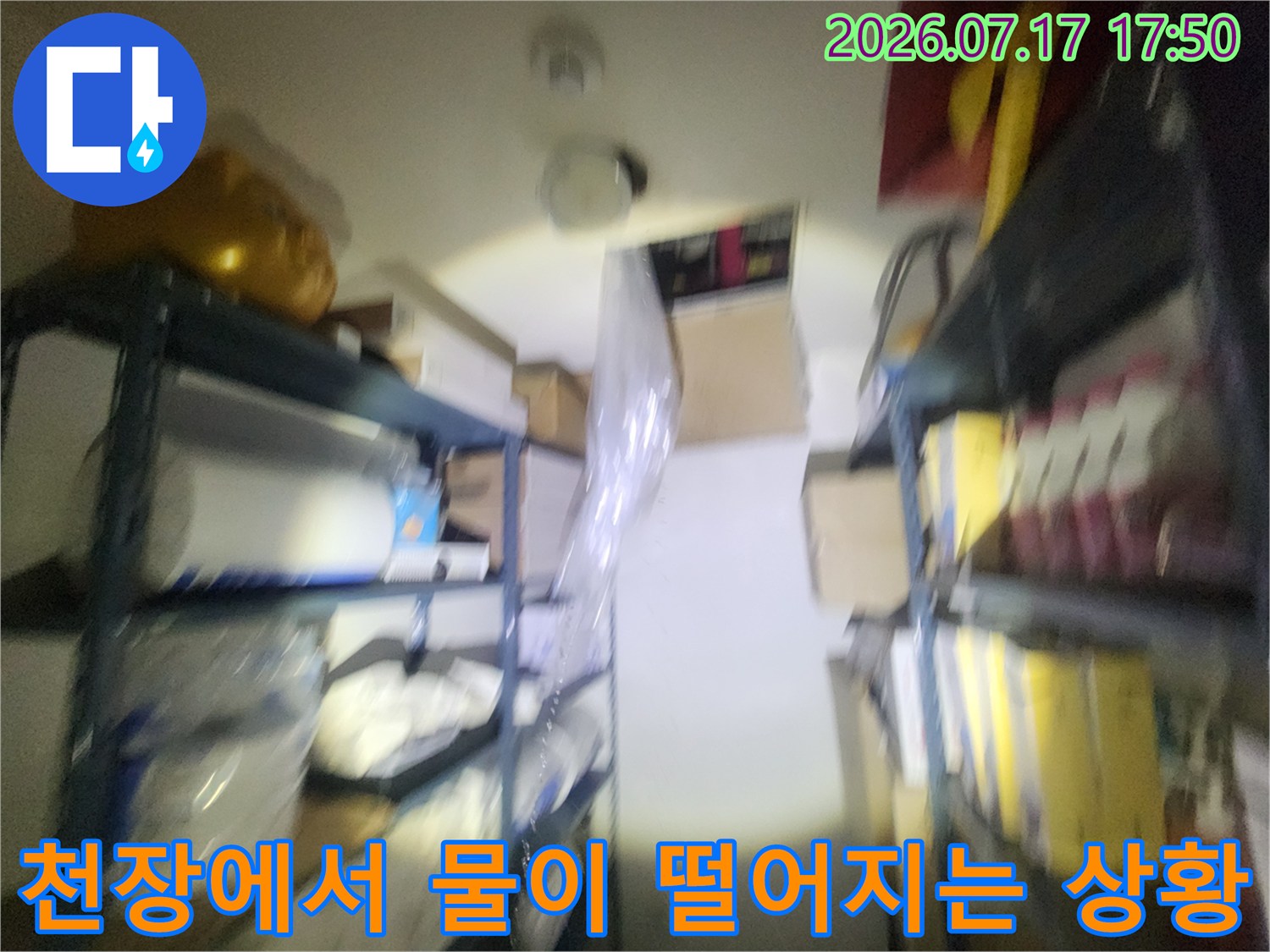 창고 내부의 선반들과-그 위쪽 천장의 누수 지점을 포착한 사진