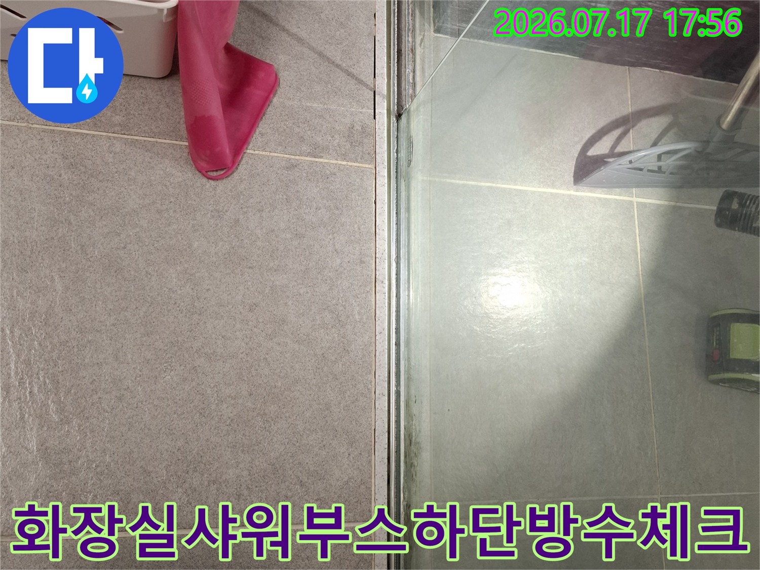 욕실 바닥 타일과 샤워 파티션 하단의 실리콘 마감 부분을 촬영한 사진