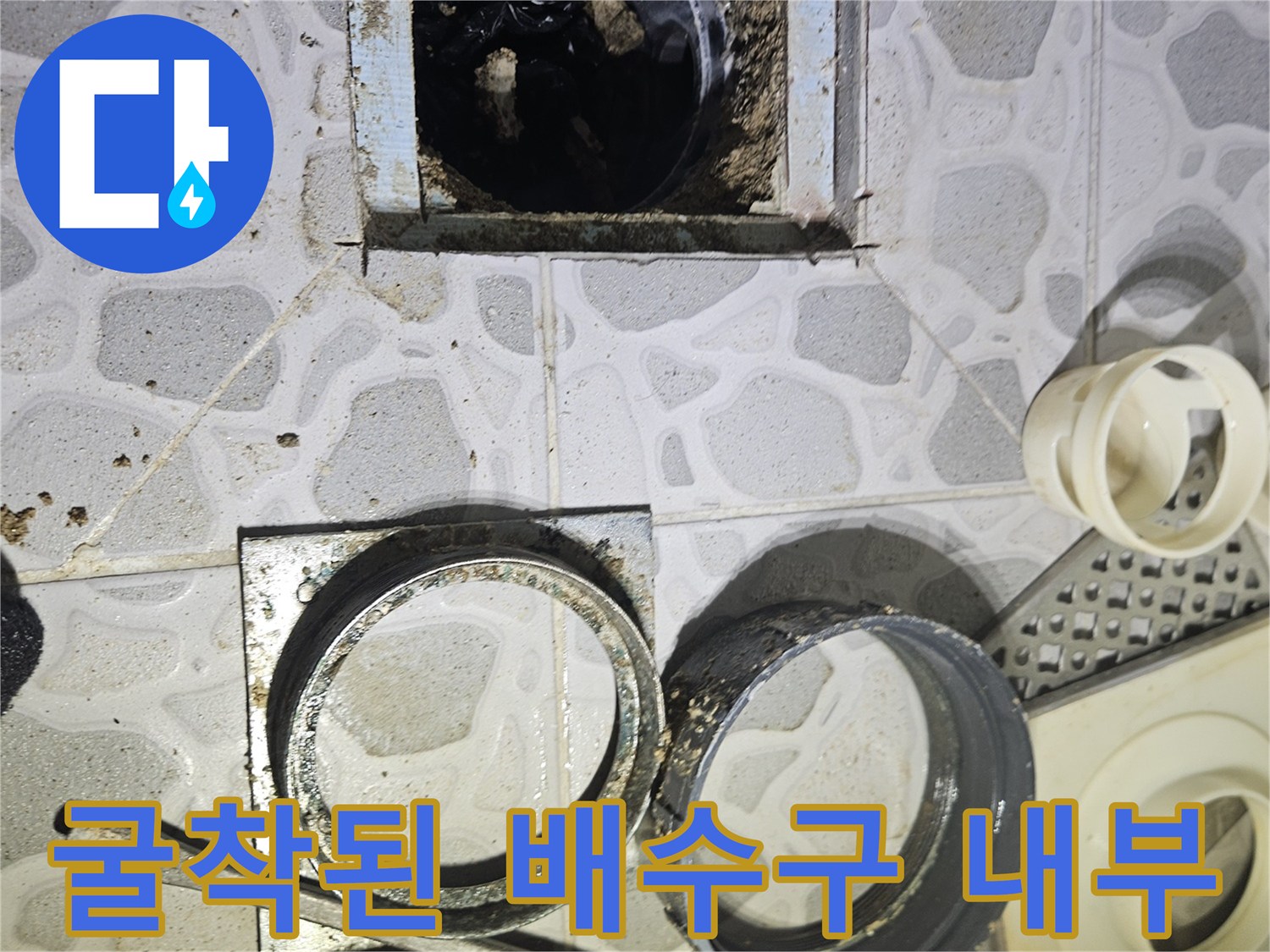 배수구 주변 타일을 제거하고 배관을 노출시킨 모습