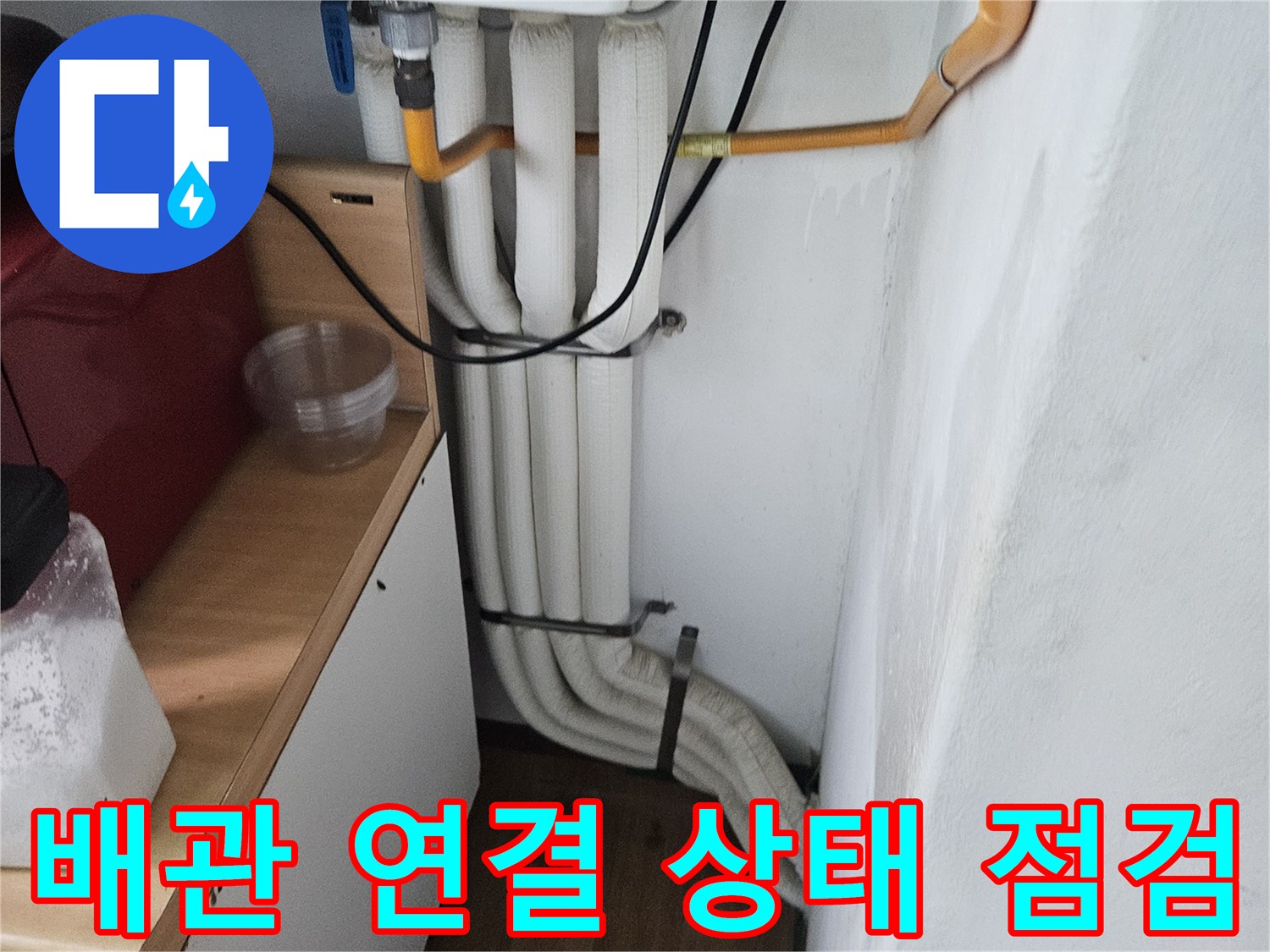 아파트 세면대 하부 배관과 노란색 수도관의 연결 부위 모습입니다.