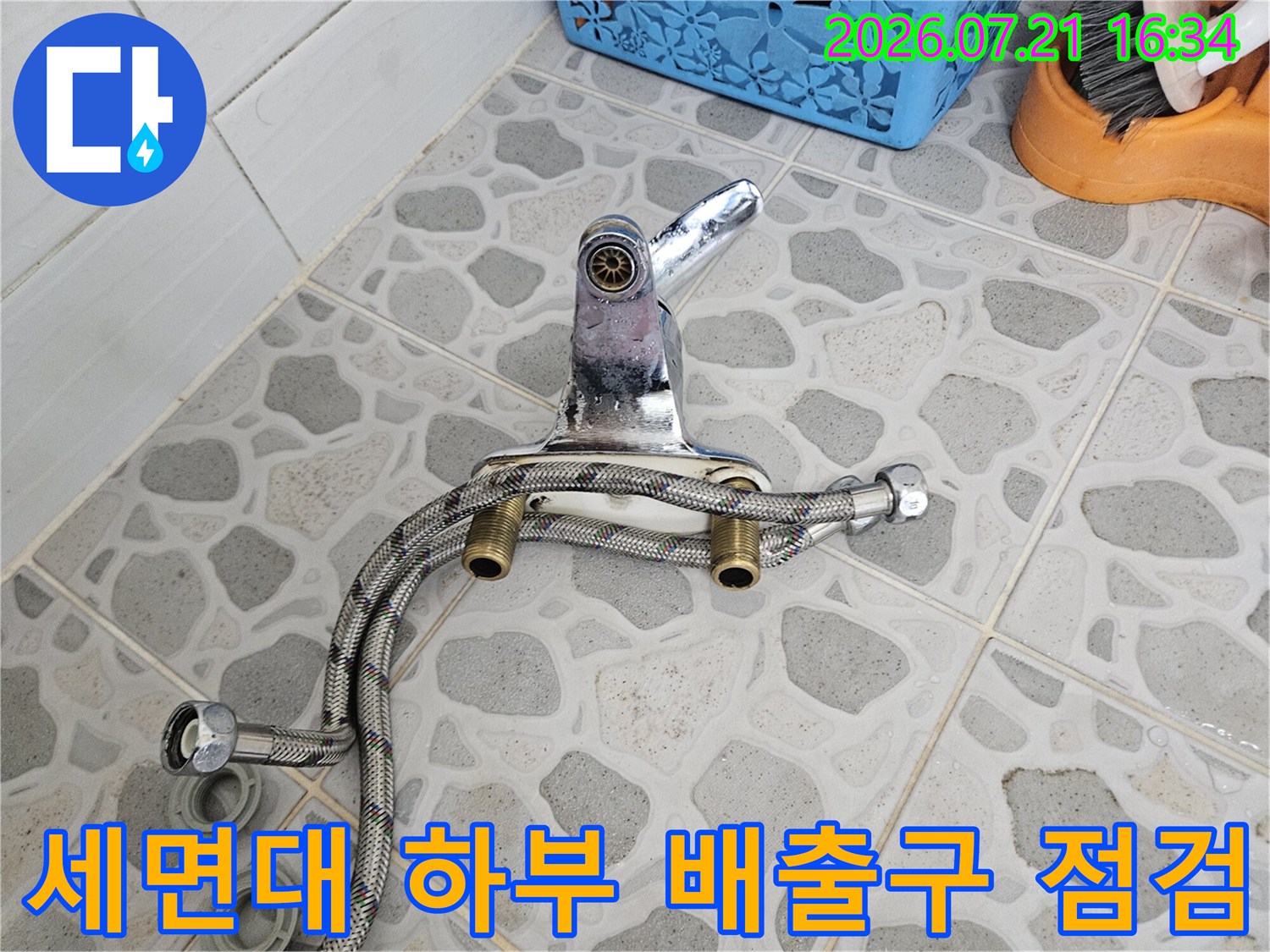 유연하게 휘어진 금속 소재의 세면대 배수 호스와 밸브 연결부