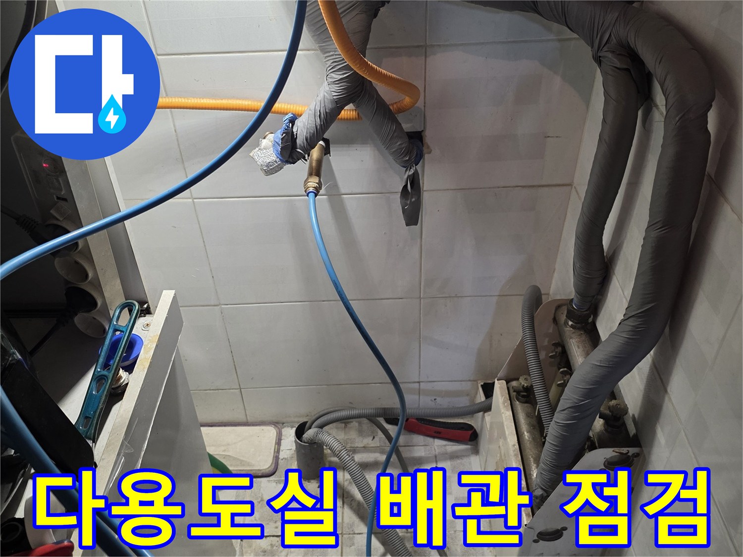 다용도실 벽면의 보온재 처리된 배관과 타일 벽면 상태를 보여줍니다.