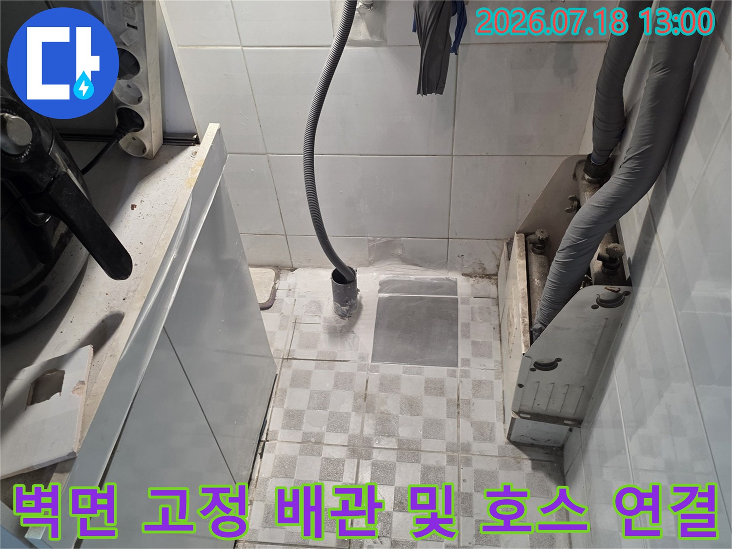 상단 회색 보온재 배관-중앙 검은색 호스-하단 흰색 가전제품 상판