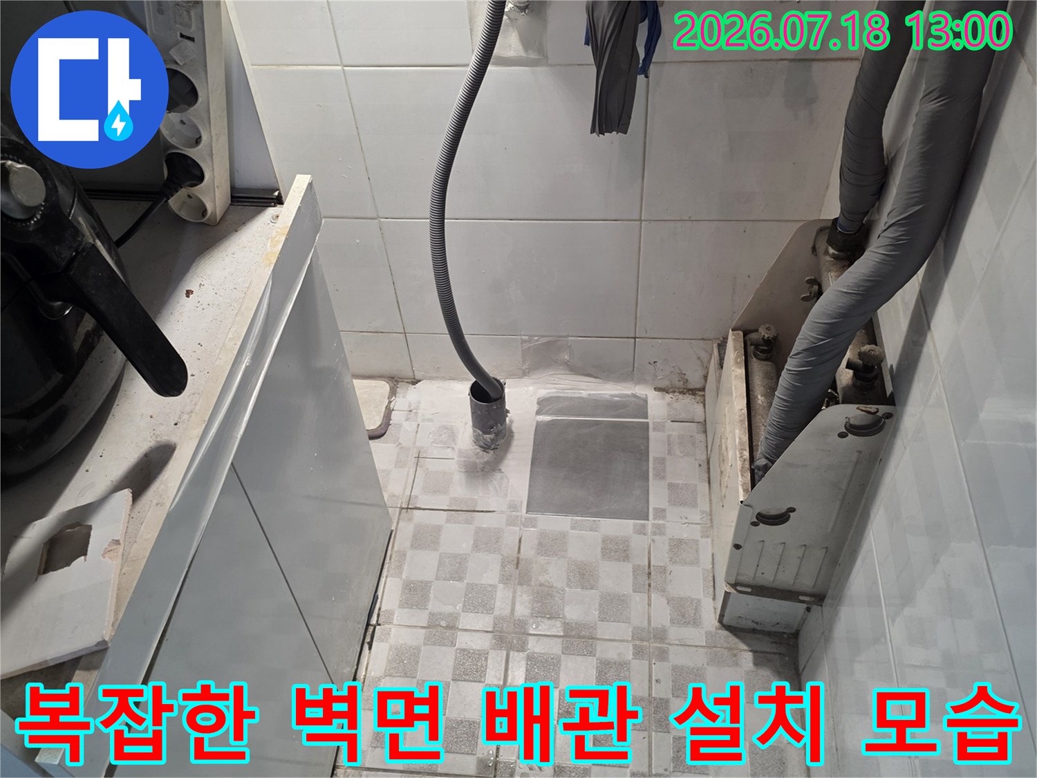 상단 회색 보온재 배관-중앙 검은색 호스-하단 흰색 가전제품 상판과 전선