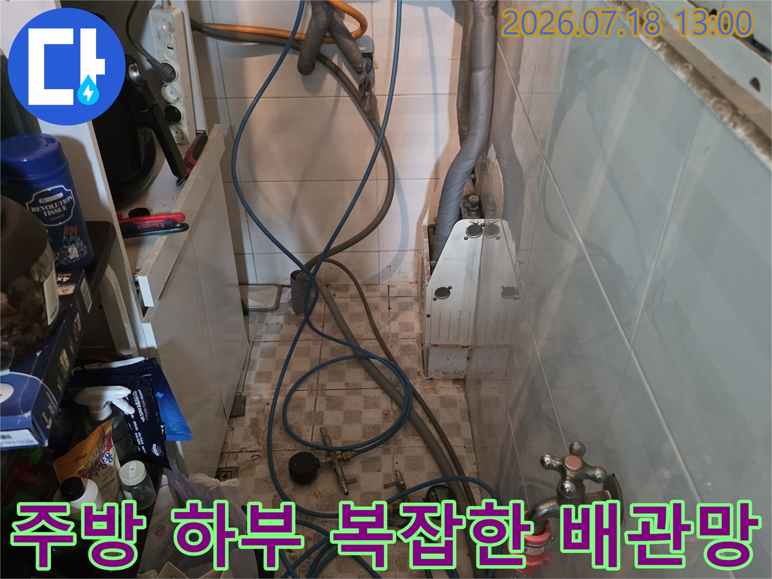 싱크대 아래쪽-벽면의 수도 밸브와 파란색 호스들이 연결된 전경