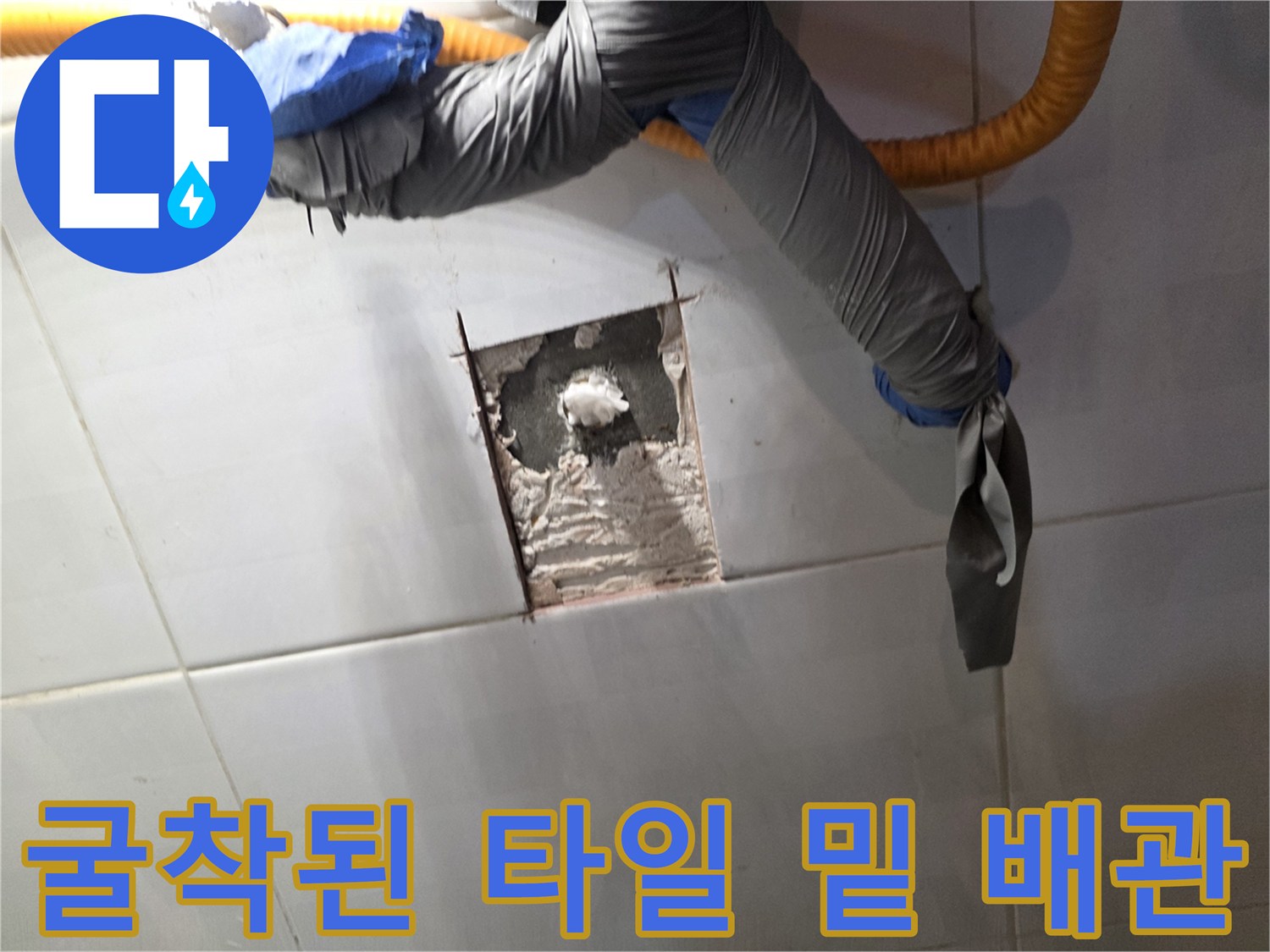 타일 아래 숨겨진 배관의 손상 부위를 드러낸 사진입니다.