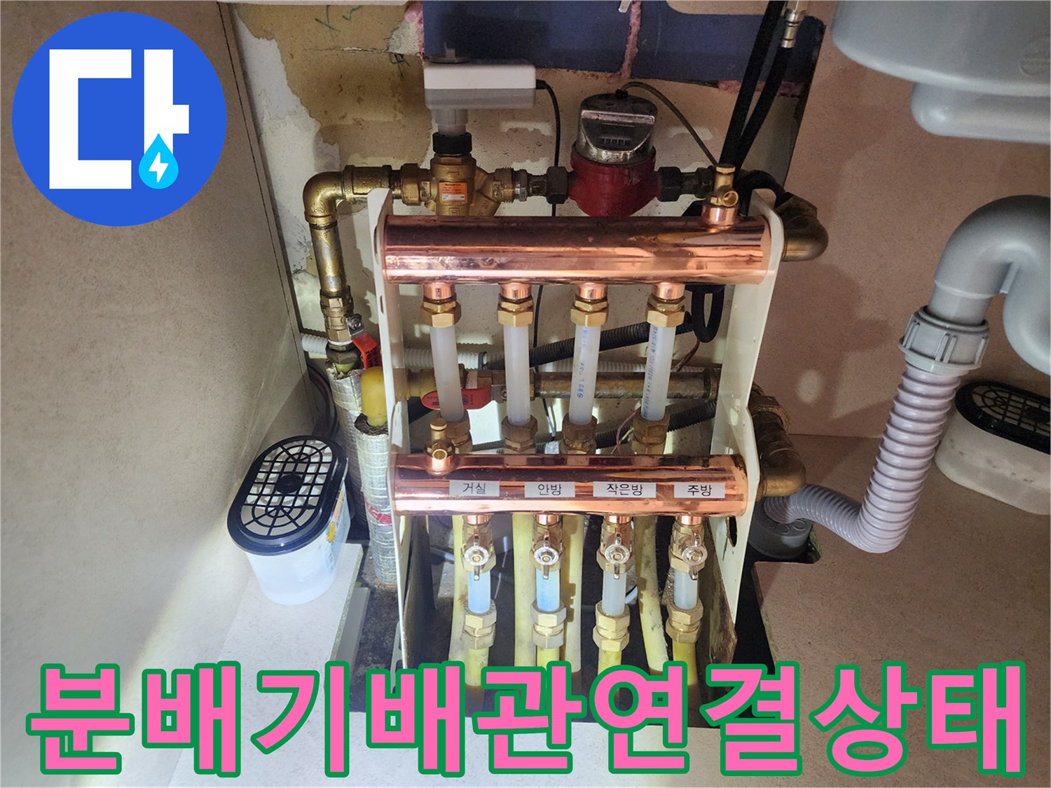싱크대 하단 난방 분배기의 구리 배관과 노란색 연결관 상세 사진