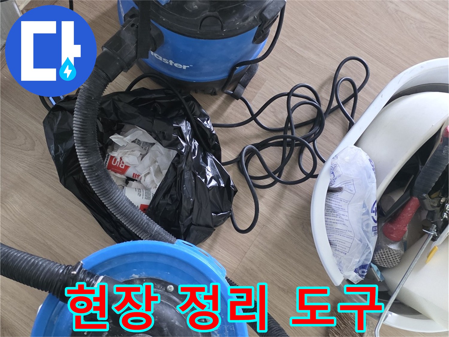 청소용 빗자루와 산업용 청소기가 놓인 공사 현장 바닥