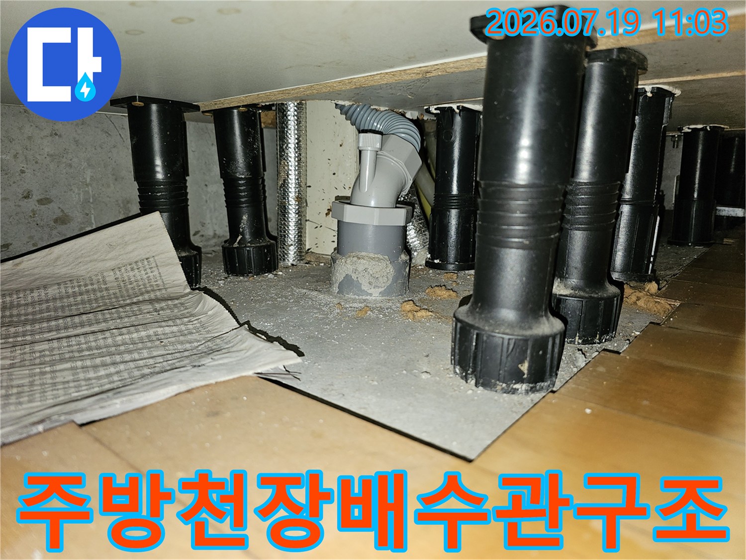 회색-플라스틱-드레인-배관과-검은색-지지대가-설치된-천장-내부-전경